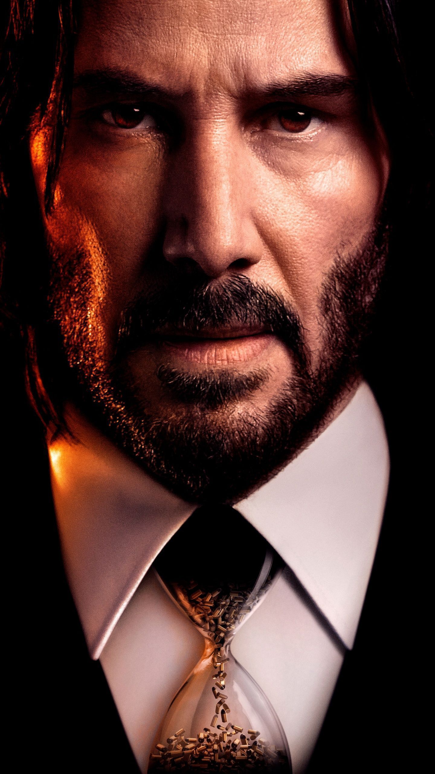 Keanu Reeves in a suit with an hourglass in front of him - John Wick