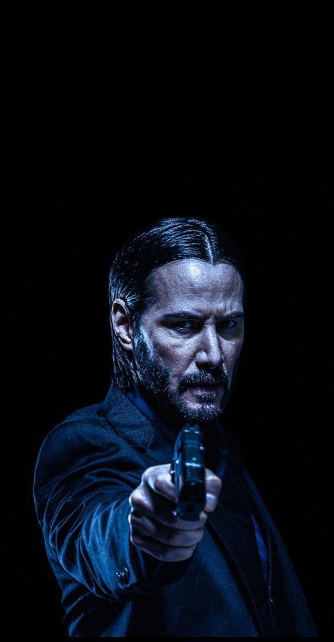 Keanu Reeves pointing a gun in the dark - John Wick