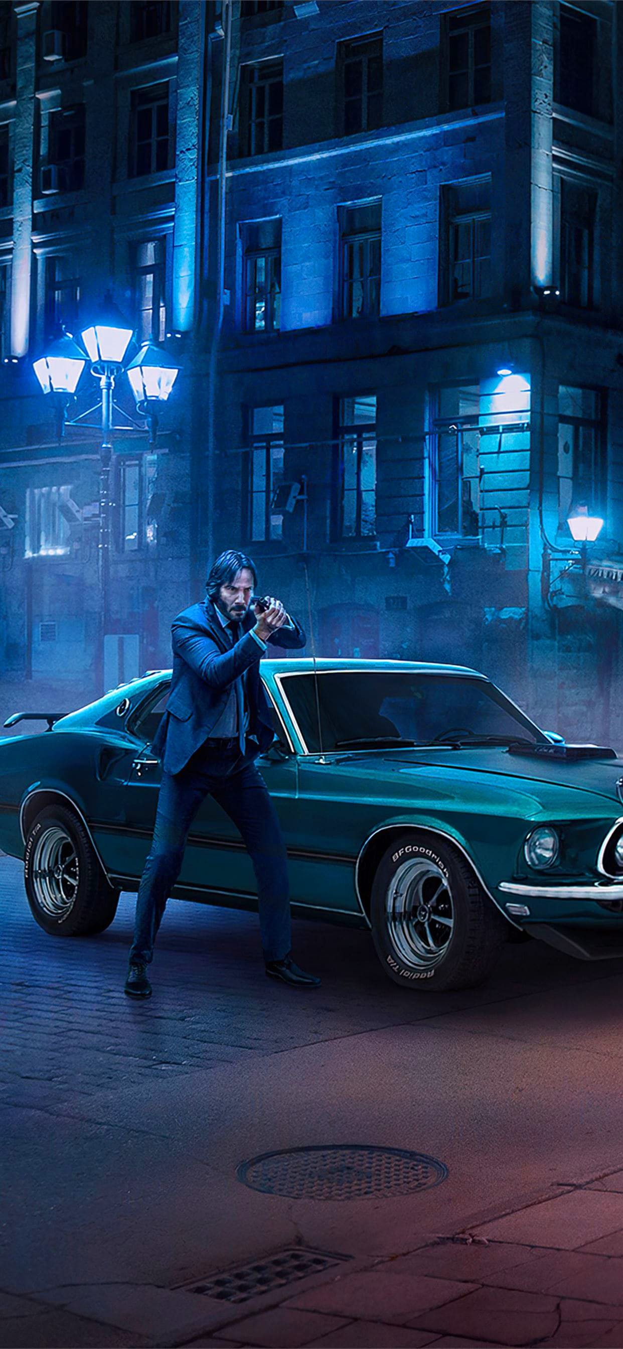 Wallpaper of John Wick holding a gun in front of a green car - John Wick