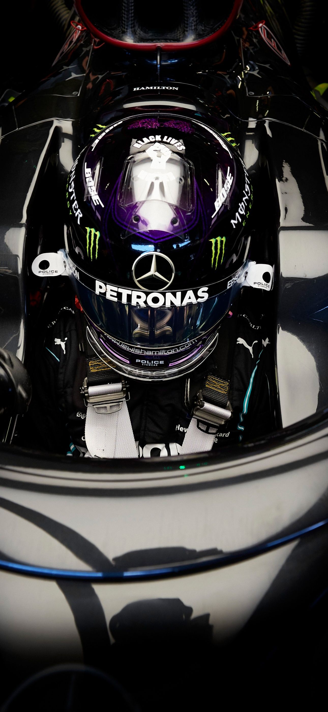 Lewis Hamilton in his Mercedes F1 car, seen through the windshield, with his helmet on. - Lewis Hamilton