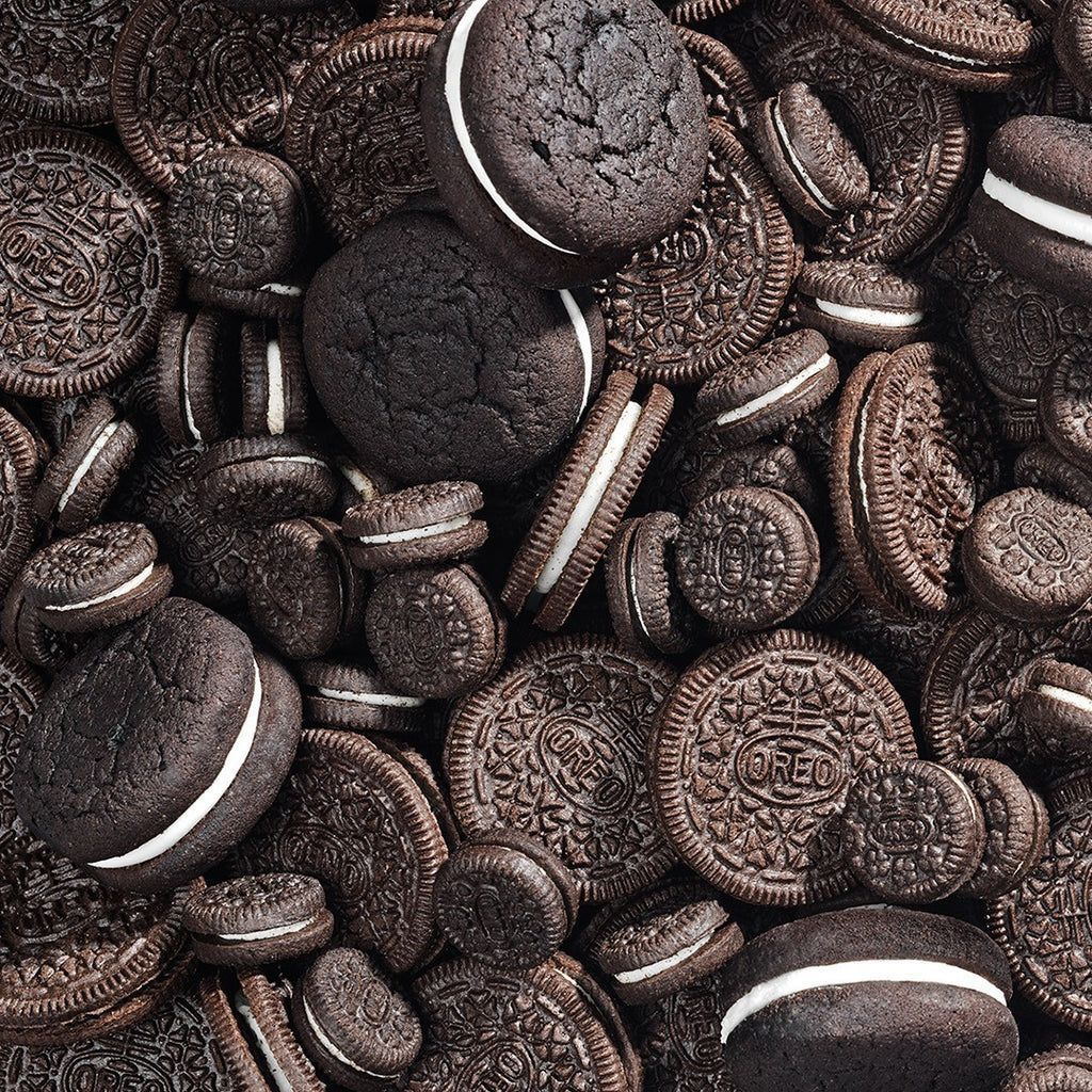 An image of a pile of chocolate sandwich cookies with white creme filling. - Oreo