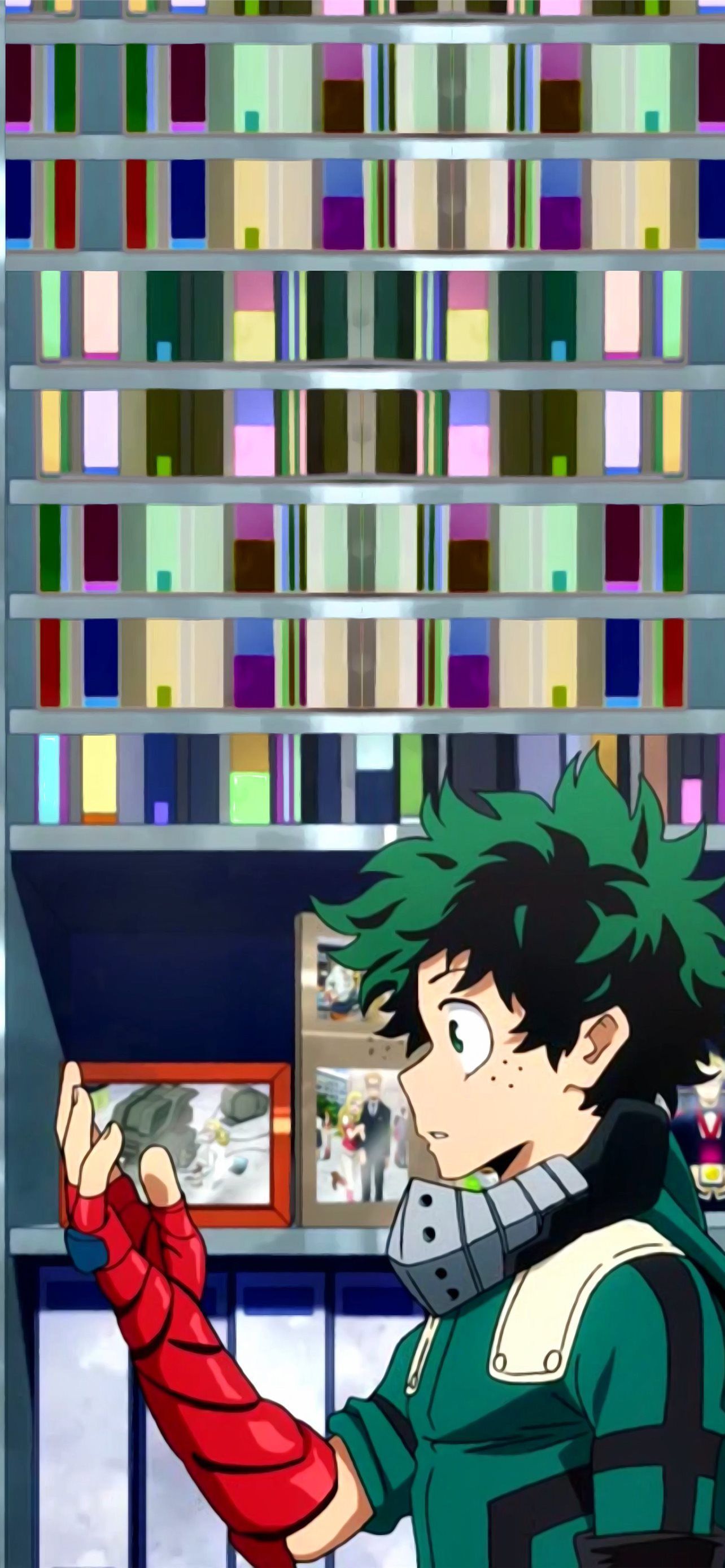 A green-haired boy in a green and brown suit puts on a red spiderman glove. - Deku
