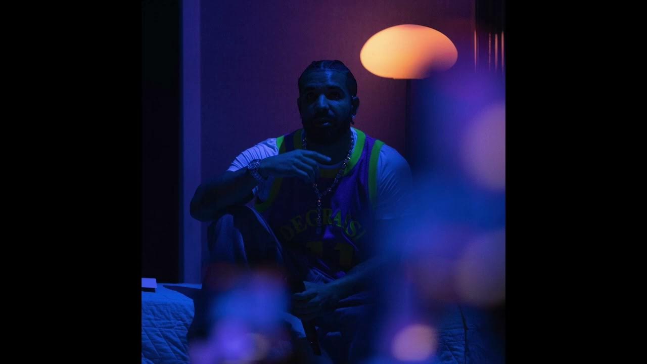 A man sitting on a bed with a purple light - Drake