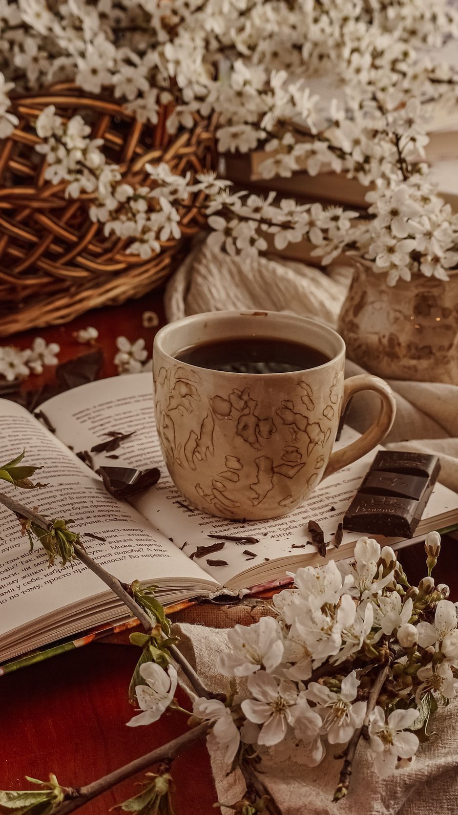 Still life of a cup of coffee, an open book, and flowers. - Chocolate