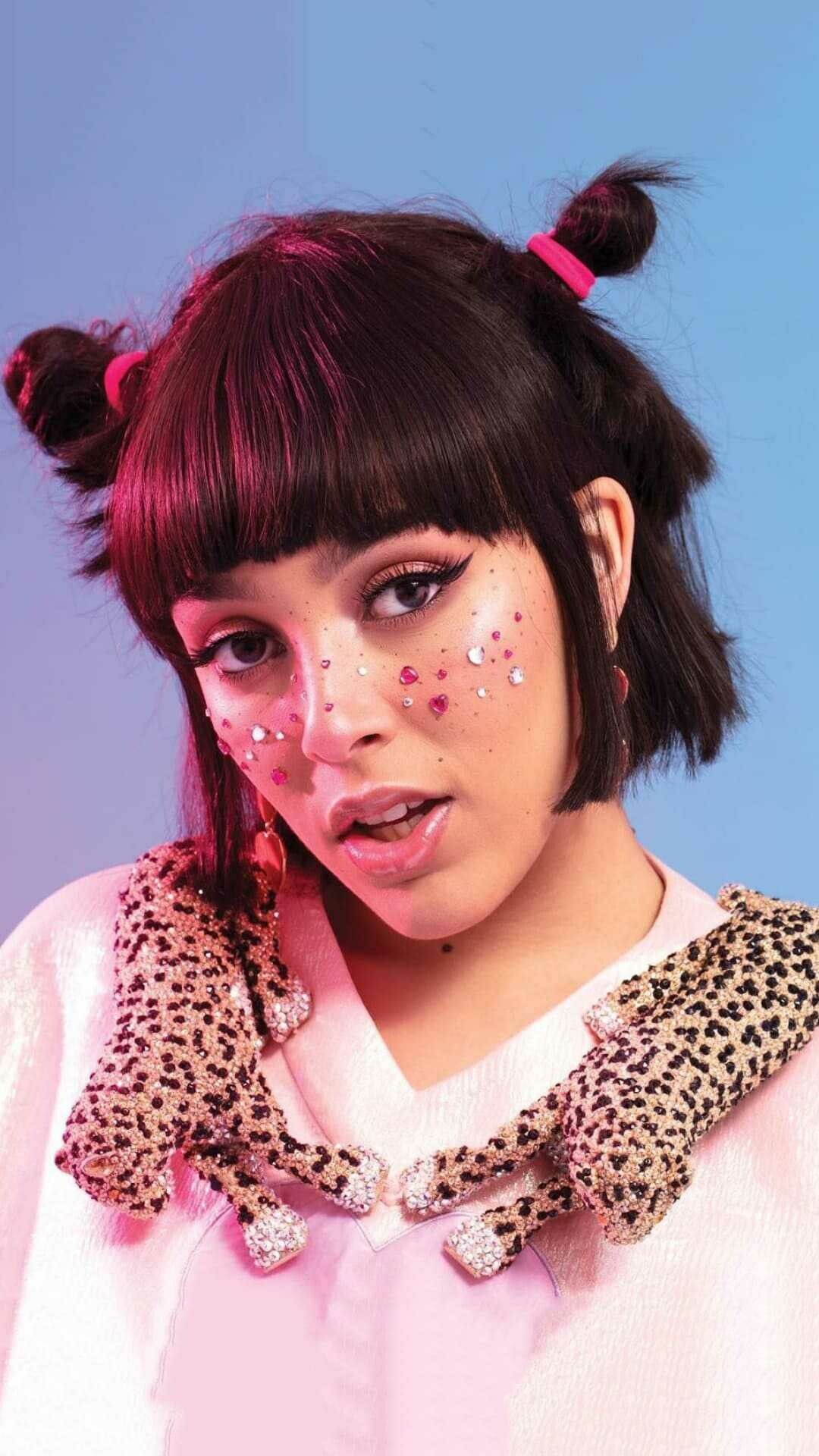 Hayley Kiyoko in a pink top with a leopard print collar and glitter on her face - Doja Cat