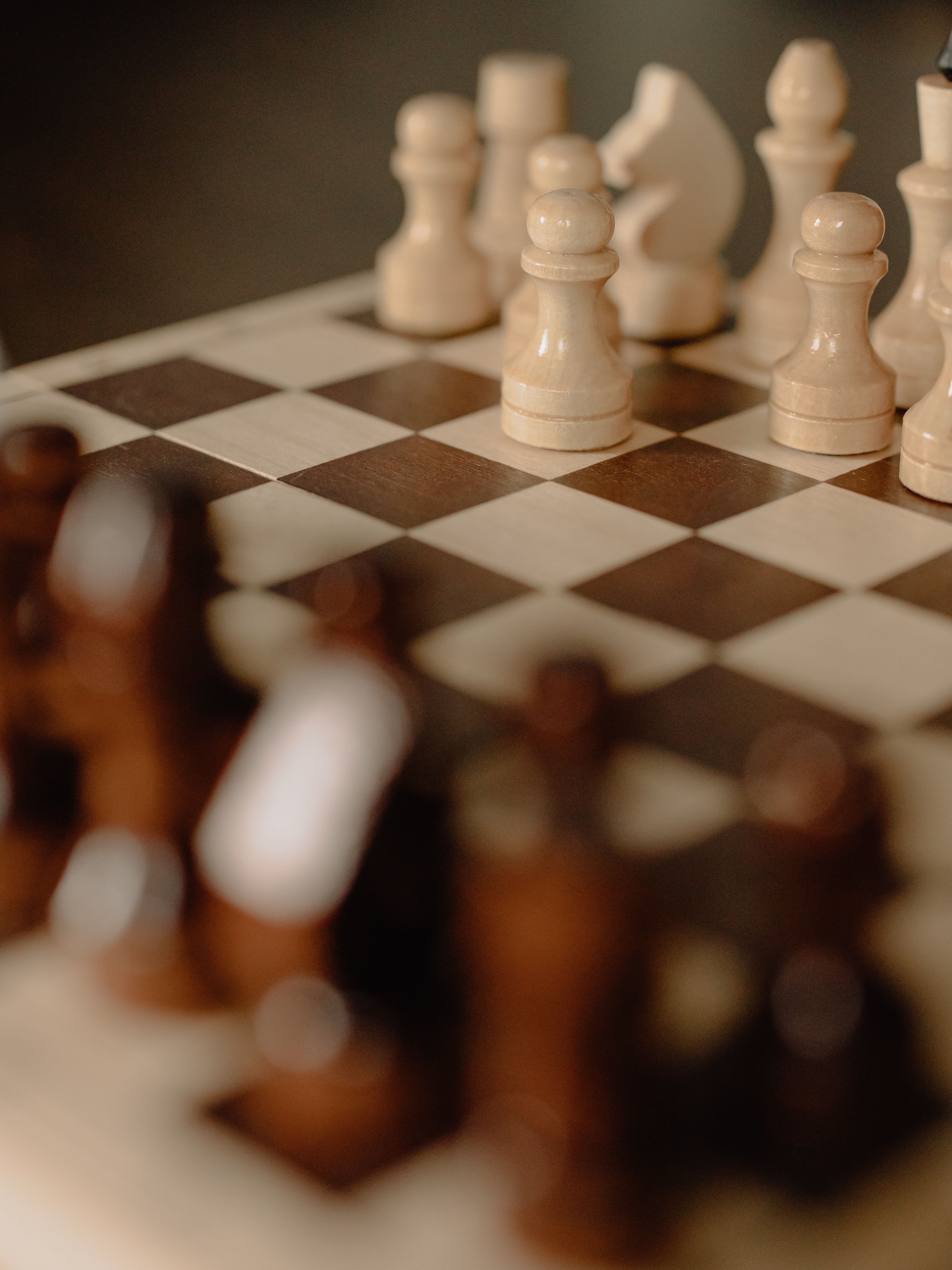 A close up of a chess board with a white chess piece on the first move. - Chess