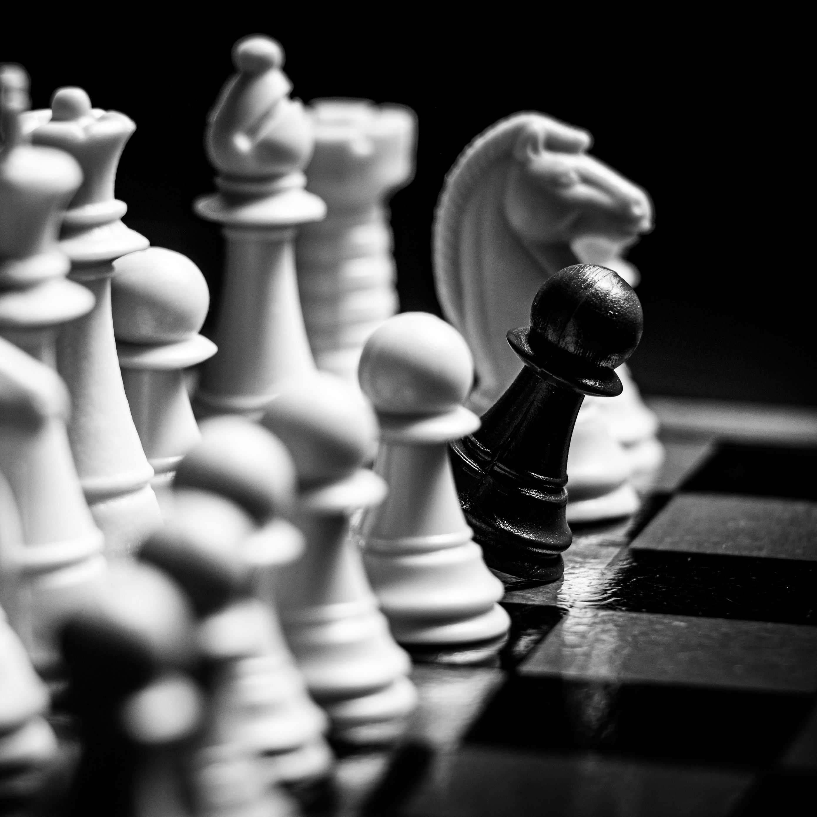A black pawn stands out from the rest of the chess pieces - Chess
