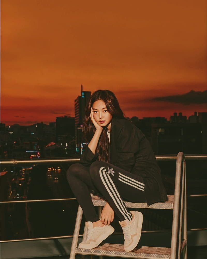 A woman sitting on top of a wooden bench. - Jennie