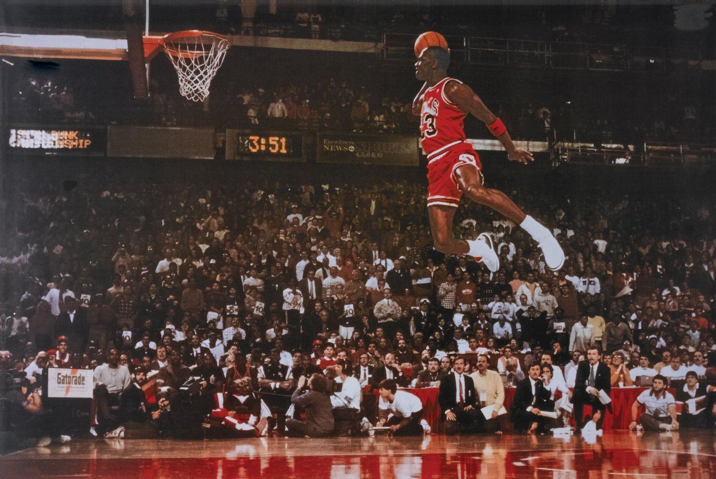Michael Jordan jumping up to dunk the ball in front of a crowd of people - Michael Jordan