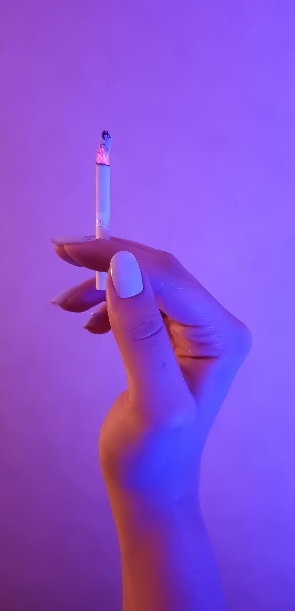 Person holding a lit cigarette - Light purple, pastel purple