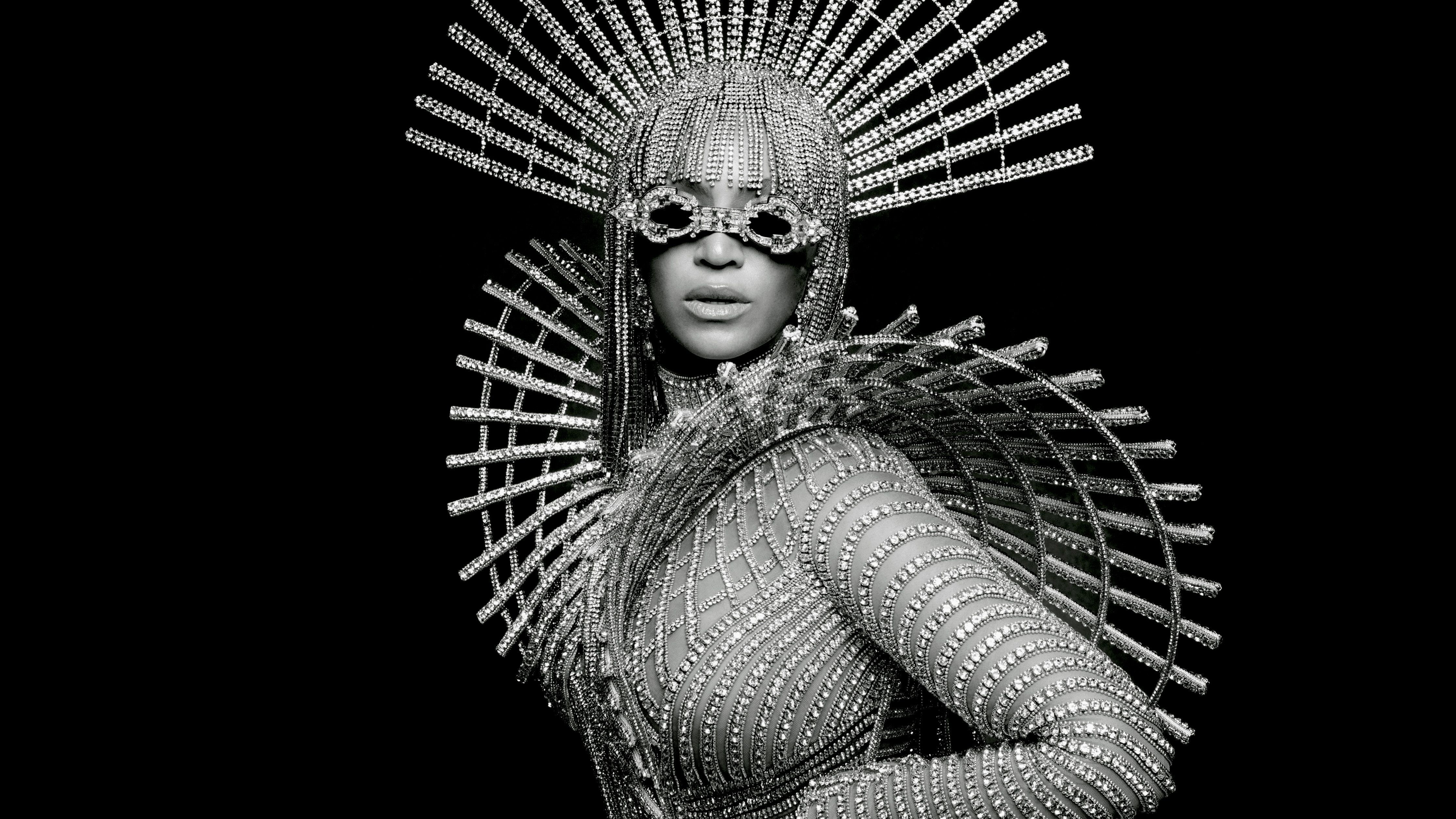 Beyoncé wearing a silver and crystal headpiece and matching costume, looking into the camera - Beyonce