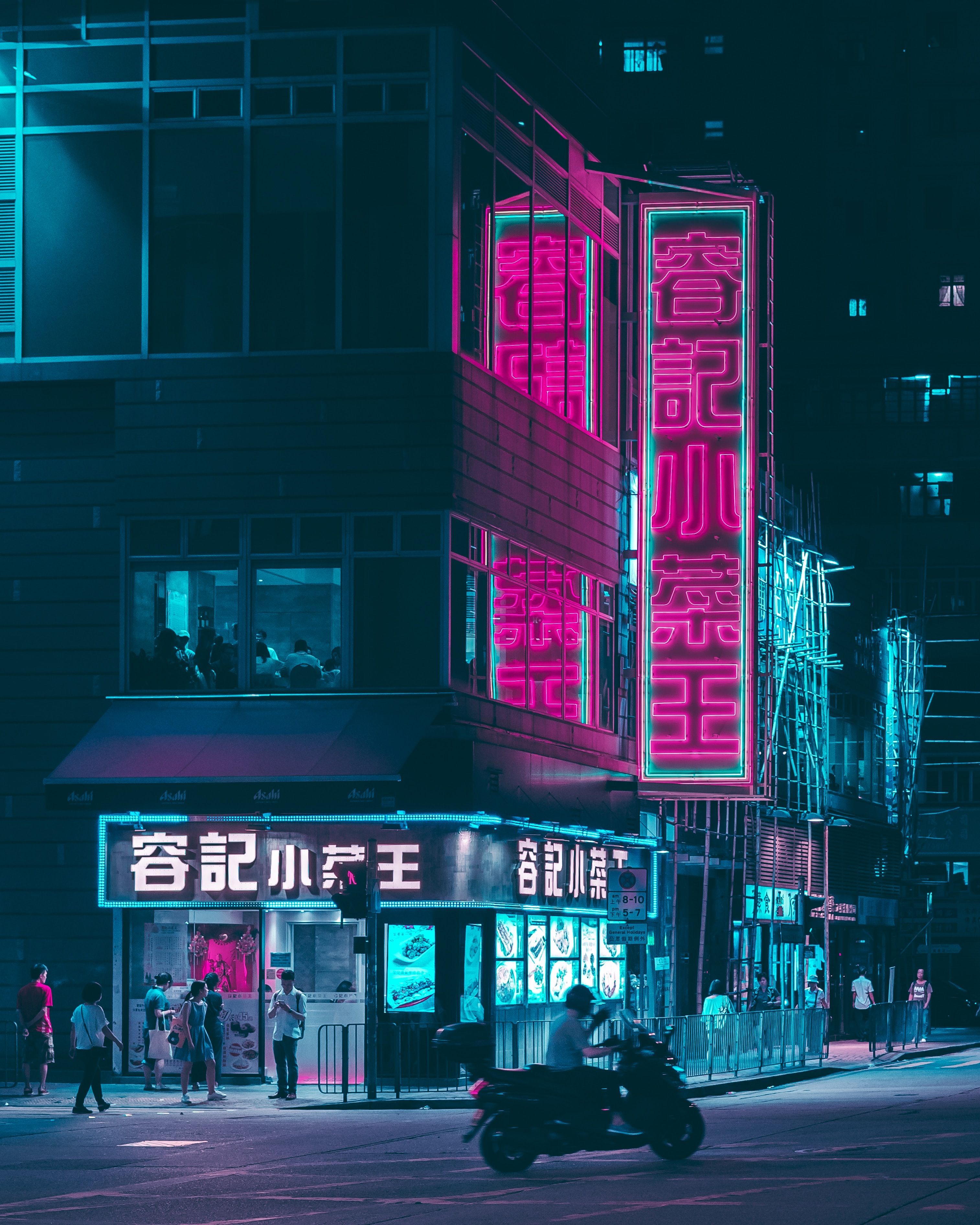 A neon-lit street at night with people walking around - HD