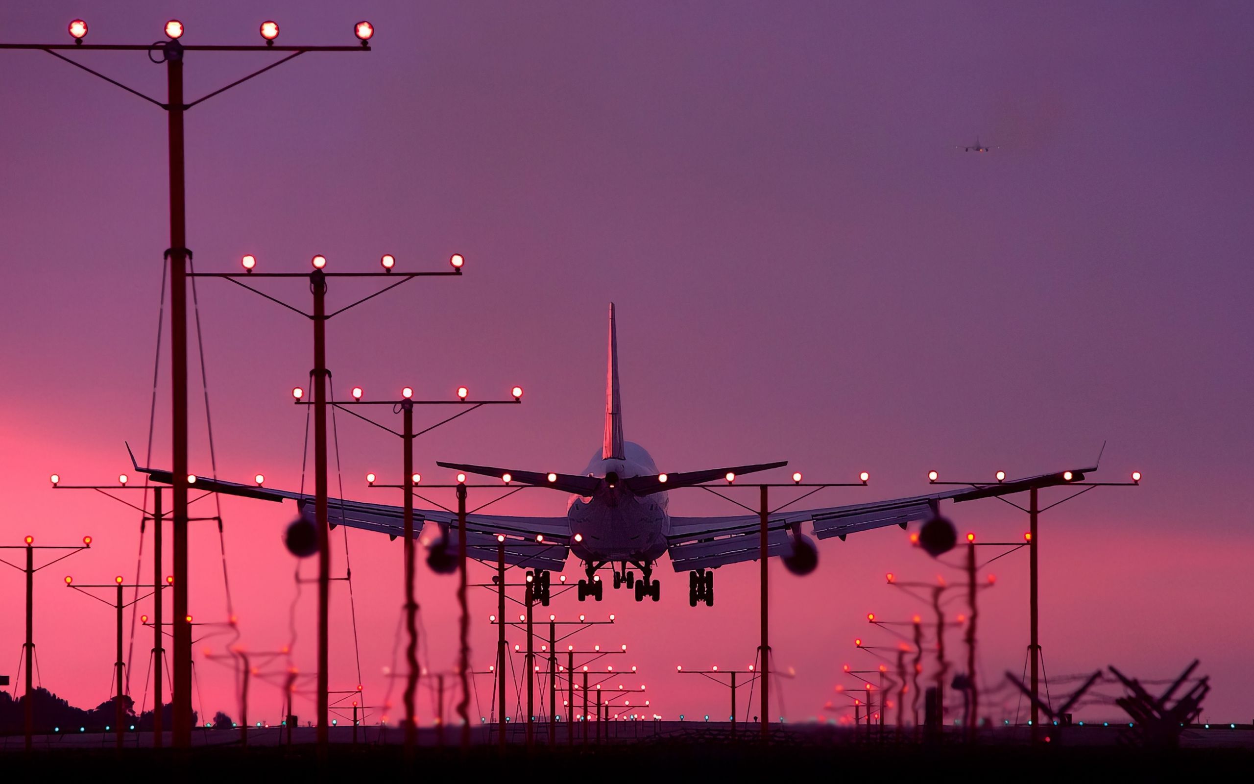 A plane flying low over a runway with lights. - 2560x1600, airplane