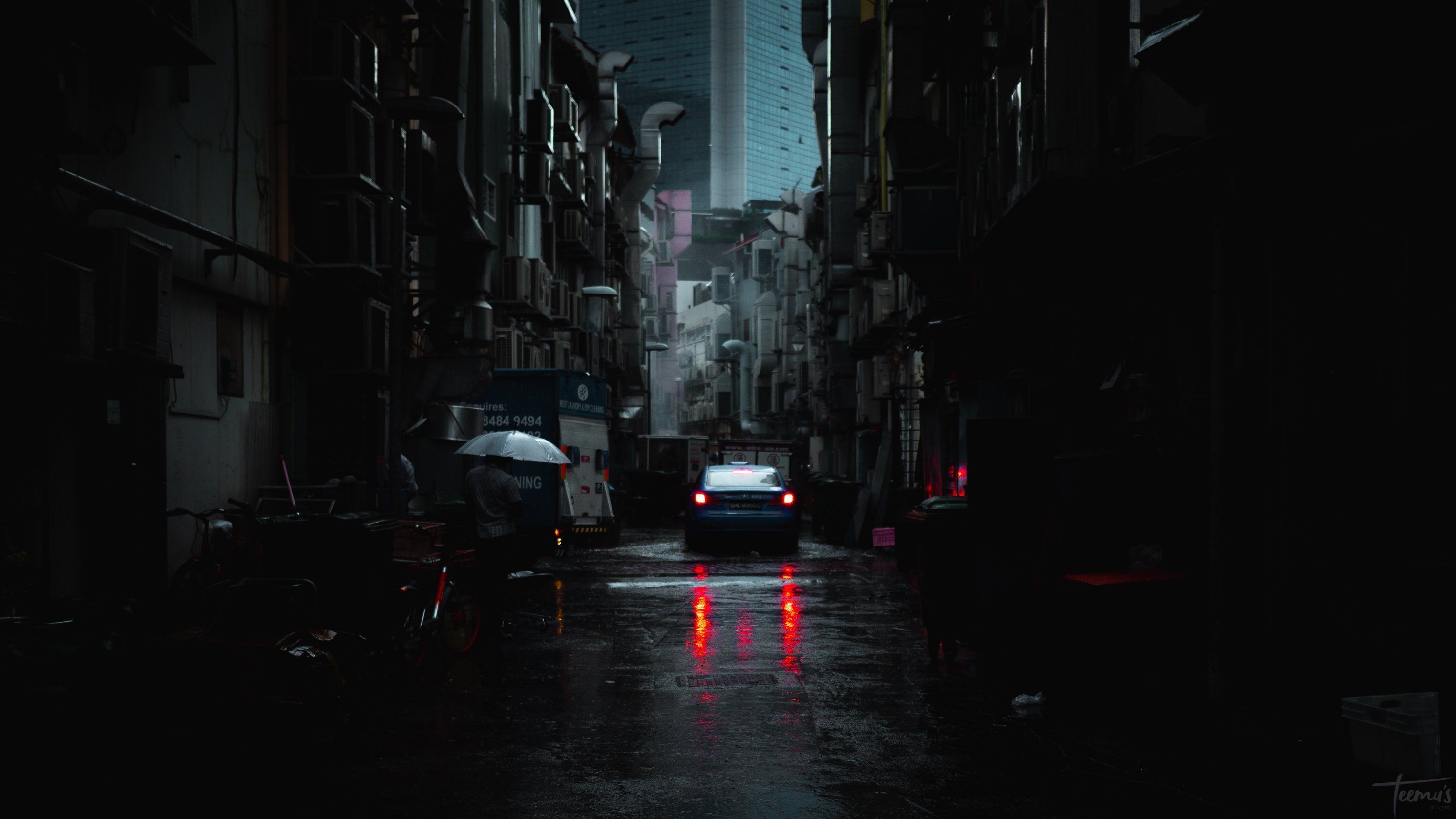 An alleyway in the rain with a car driving away - Cyberpunk 2077
