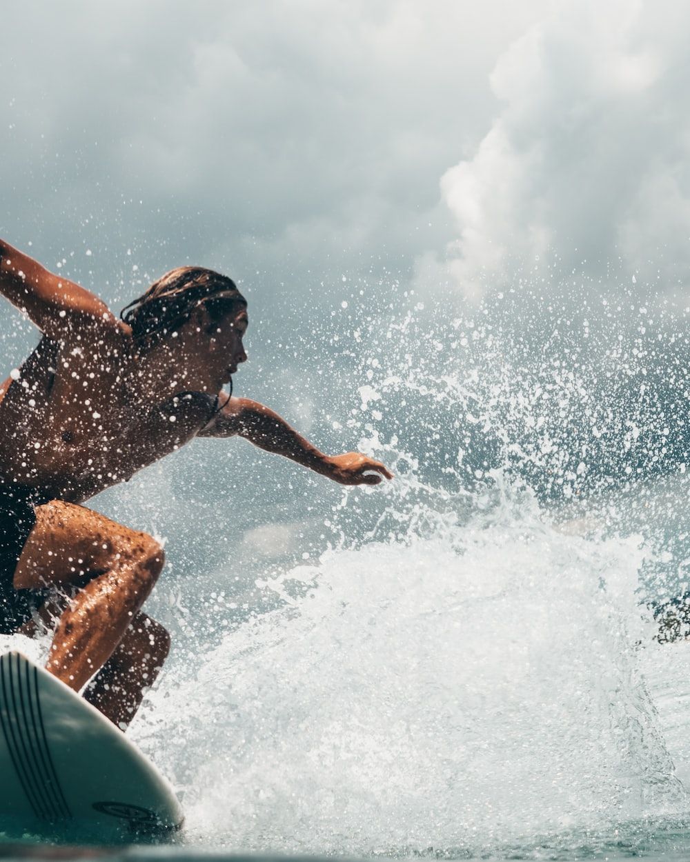 A man riding a surfboard on top of a wave. - Surf