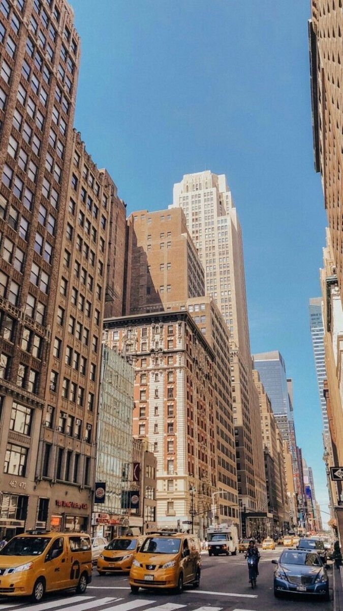 A busy city street with tall buildings on either side - New York