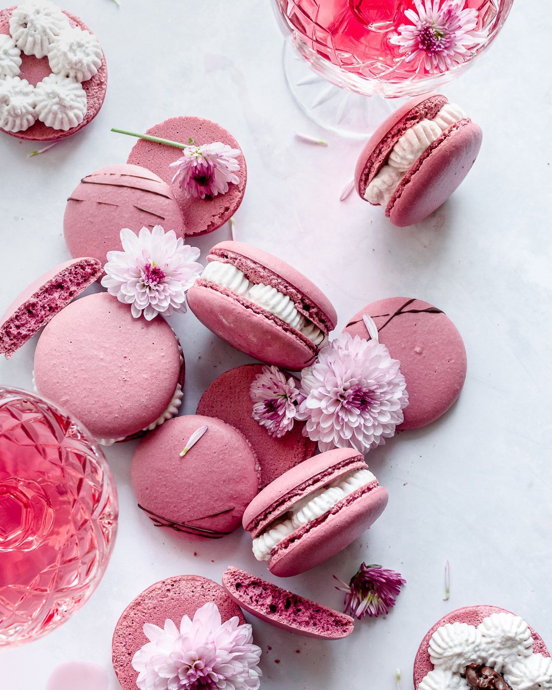 Pink macarons with flowers on a white table. - Macarons