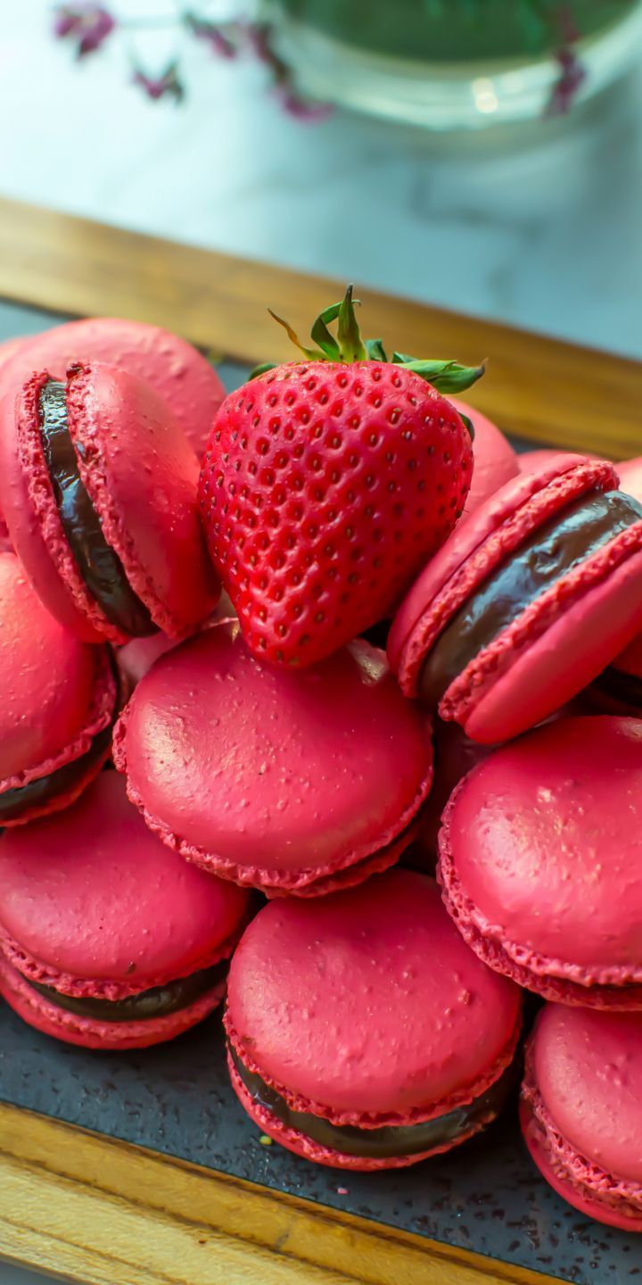 A plate of macarons with a strawberry on top. - Macarons