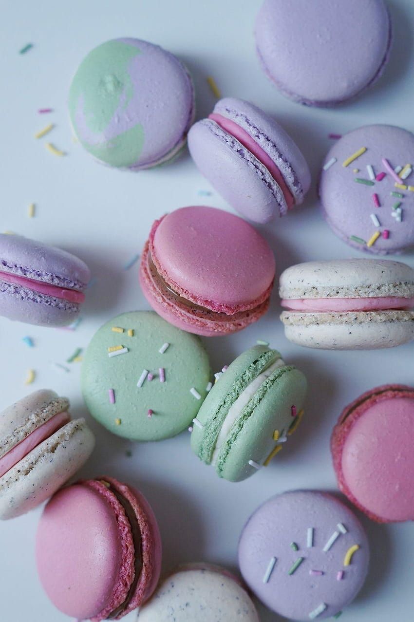 A bunch of macarons with sprinkles on a white table - Macarons