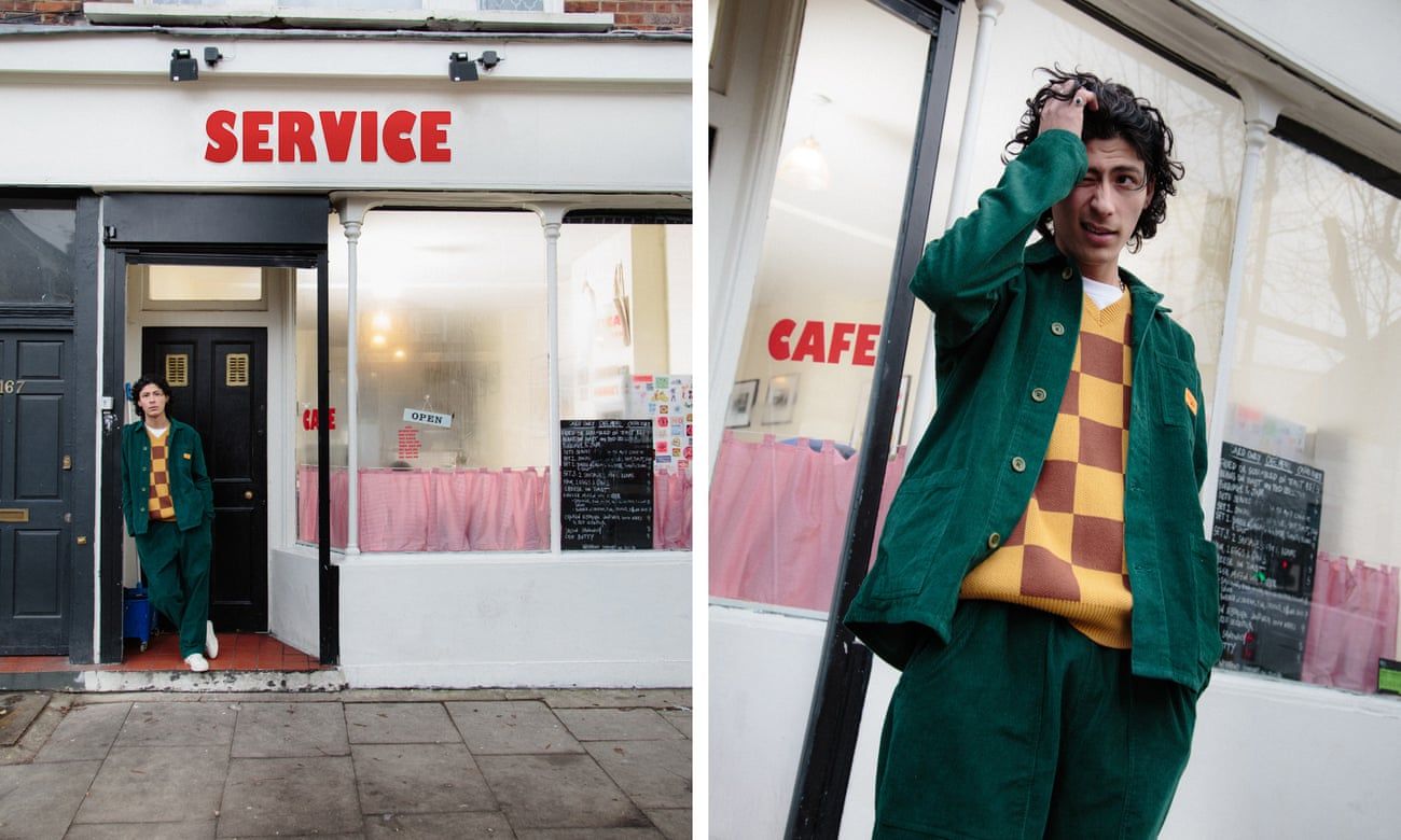 A man in a green corduroy jacket and matching trousers stands in front of a cafe. - Chefcore