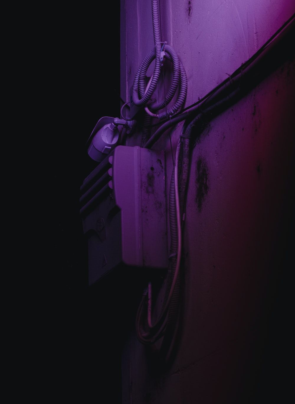 A black coated wire on white wall photo. - Dark vaporwave
