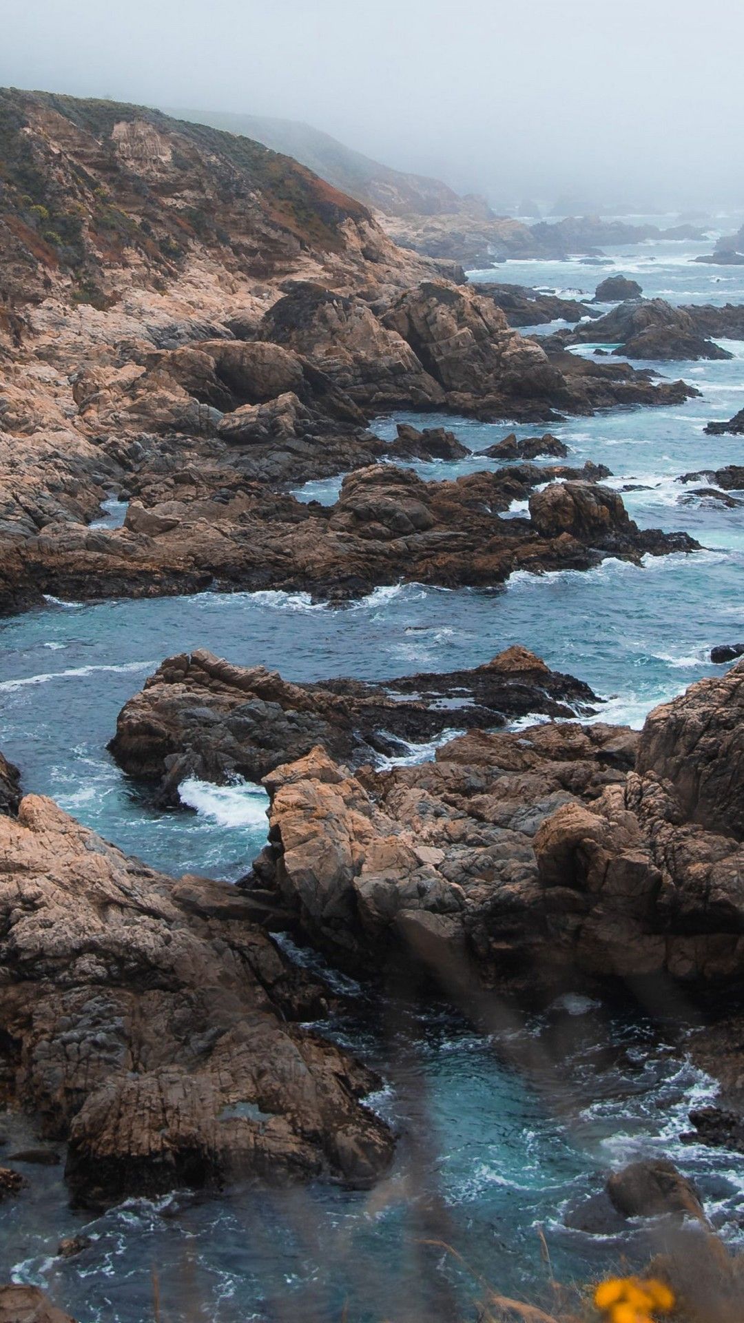 A rocky coastline with waves crashing against the rocks - Coast