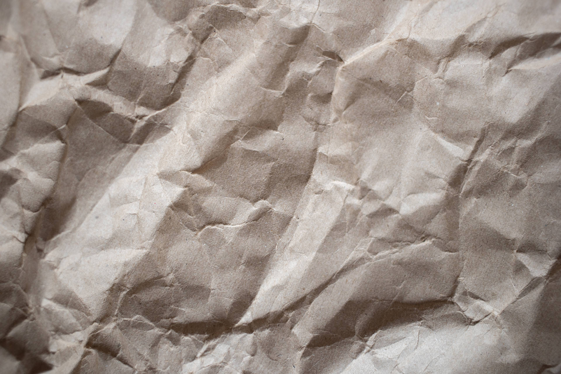 A close up of a crumpled piece of brown paper. - Paper