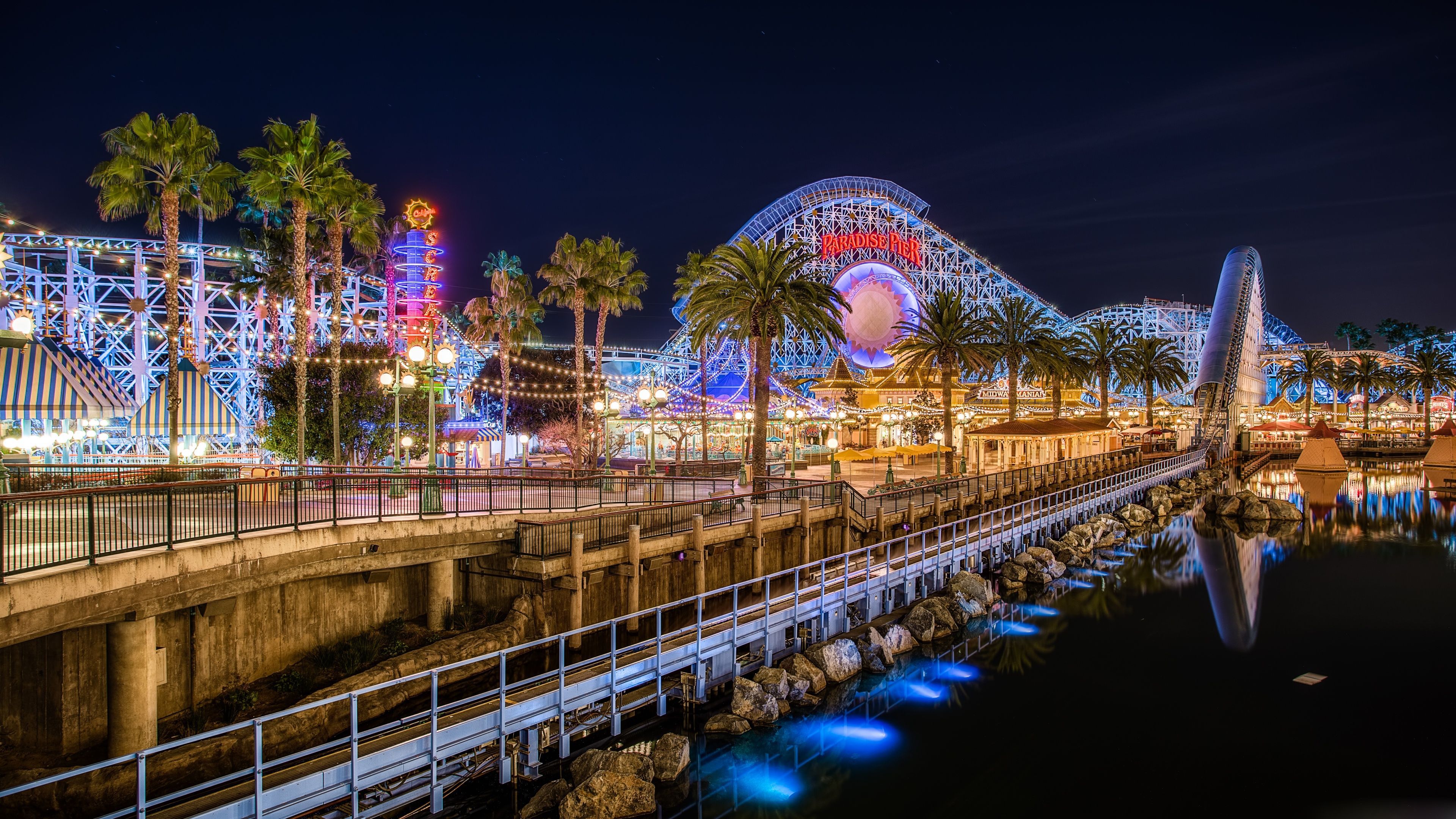 A nighttime view of the Paradise Pier and the roller coaster. - California