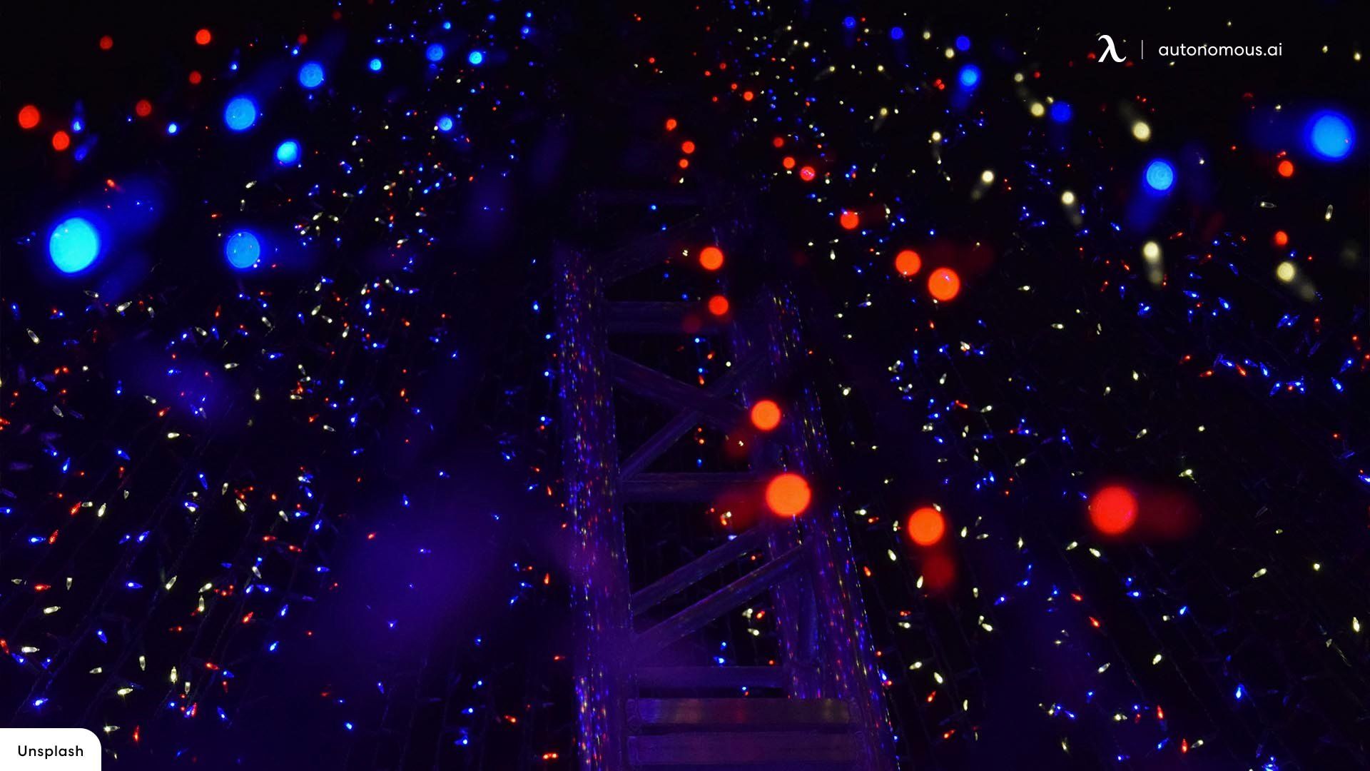 A dark room with a ladder and a lot of blue and red dots. - Christmas lights