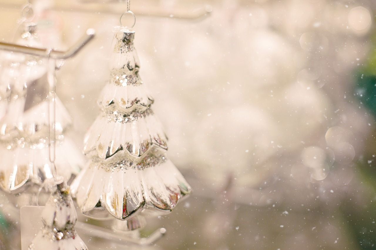 A white Christmas tree ornament hanging from a tree. - Christmas lights
