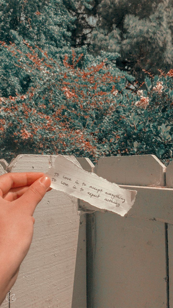 A person holding a piece of paper with a quote on it. - NCT