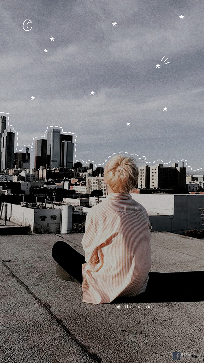 Wallpaper of a blonde guy sitting on a rooftop - Jimin