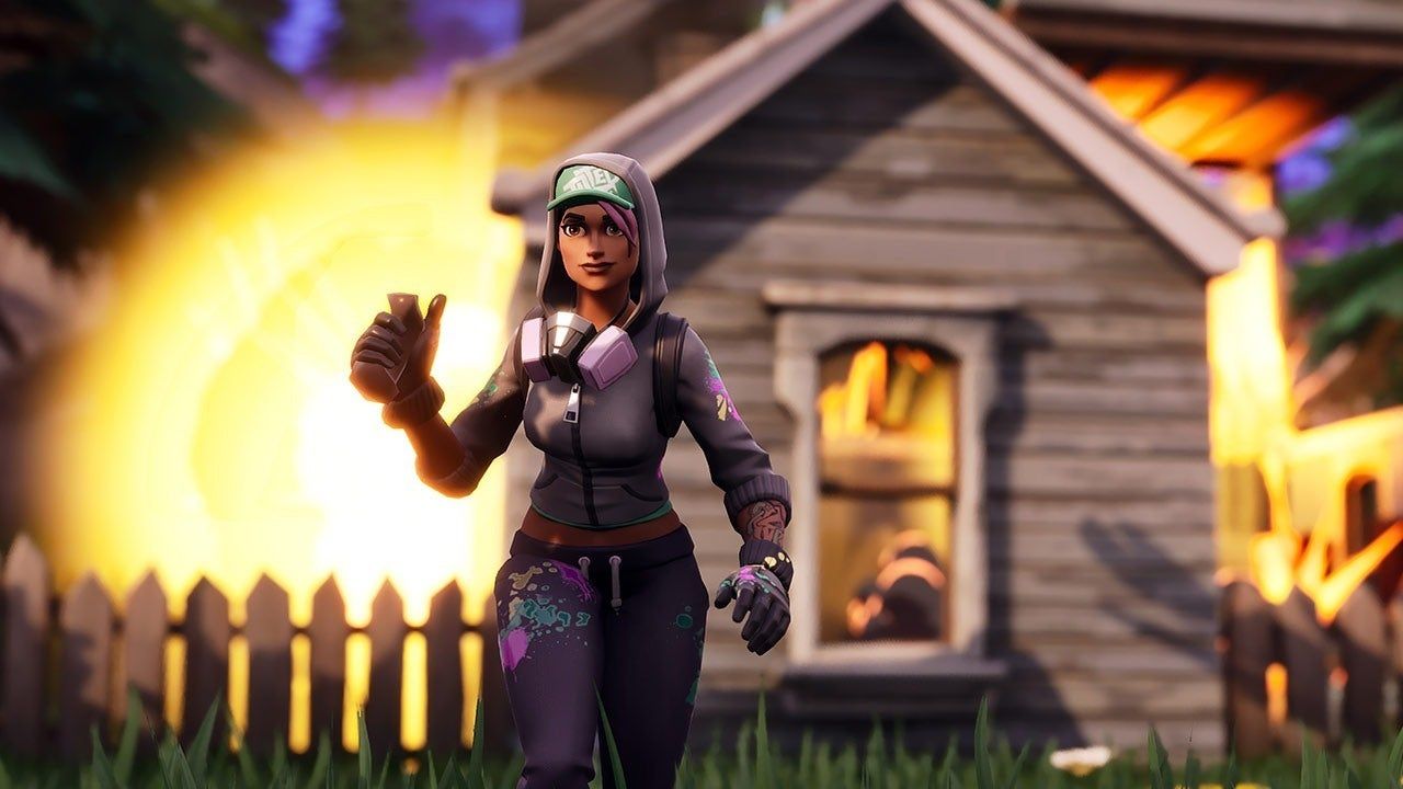 A Fortnite character wearing purple and black stands in front of a burning house - Fortnite