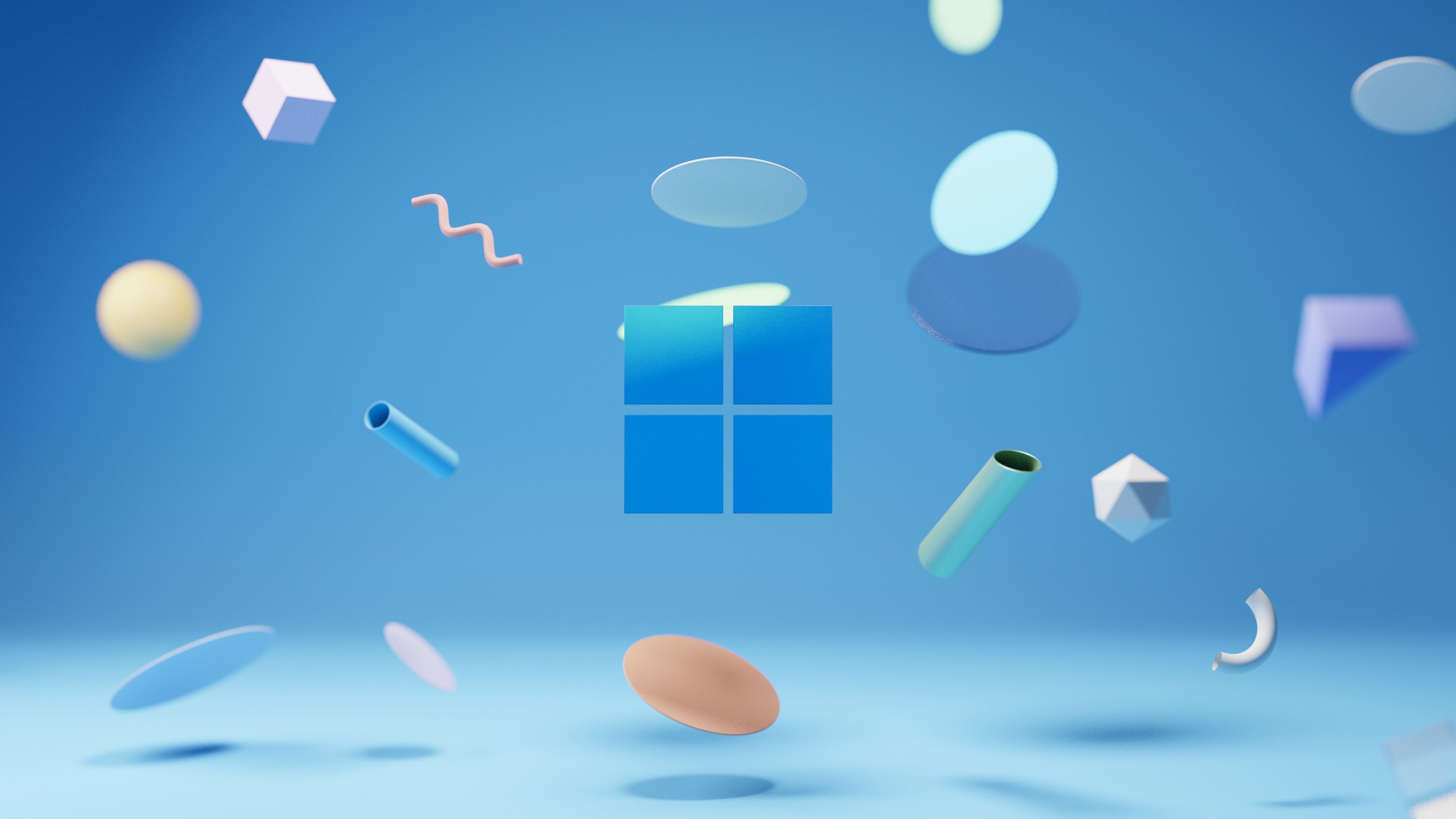 A Windows 11 wallpaper featuring a blue Windows logo surrounded by floating shapes - Windows 11