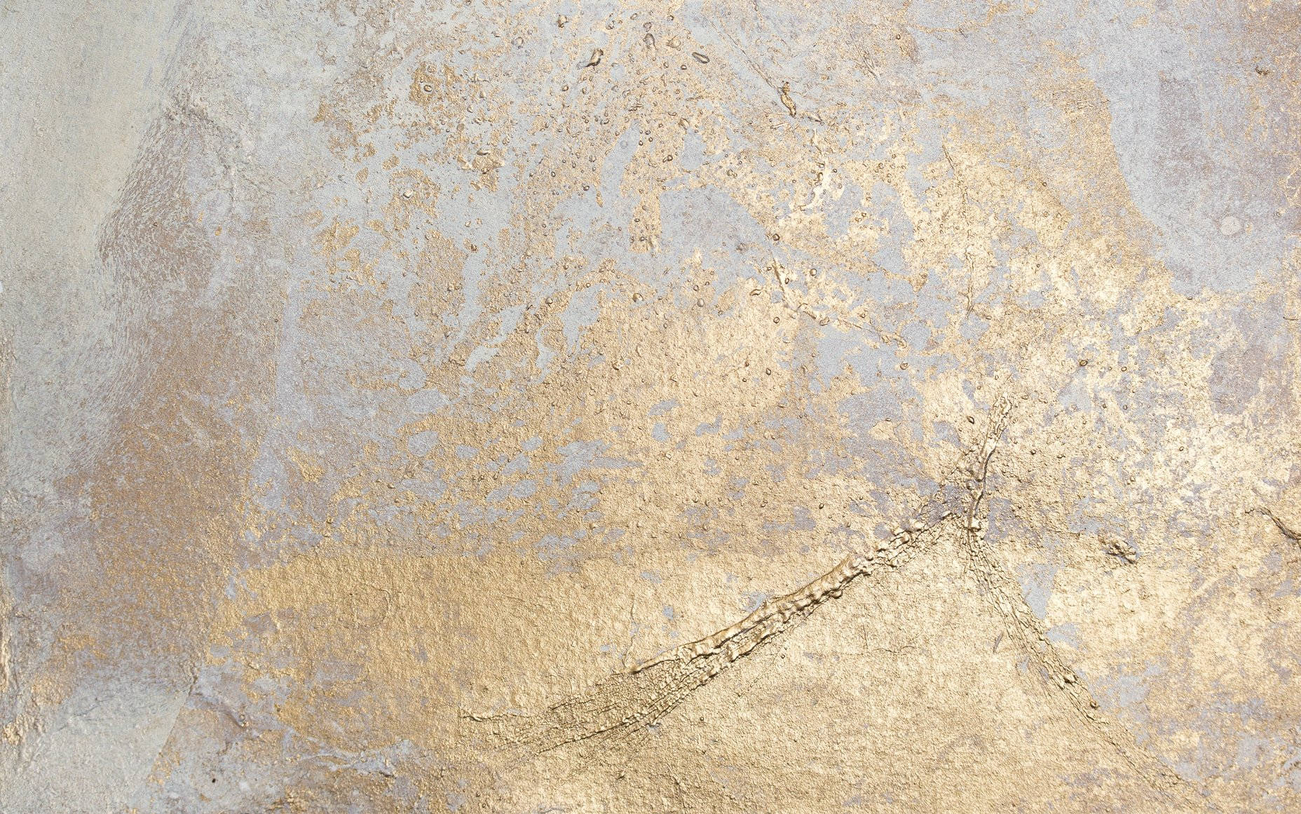 A close up of a wall with a gold and grey paint design - Gold