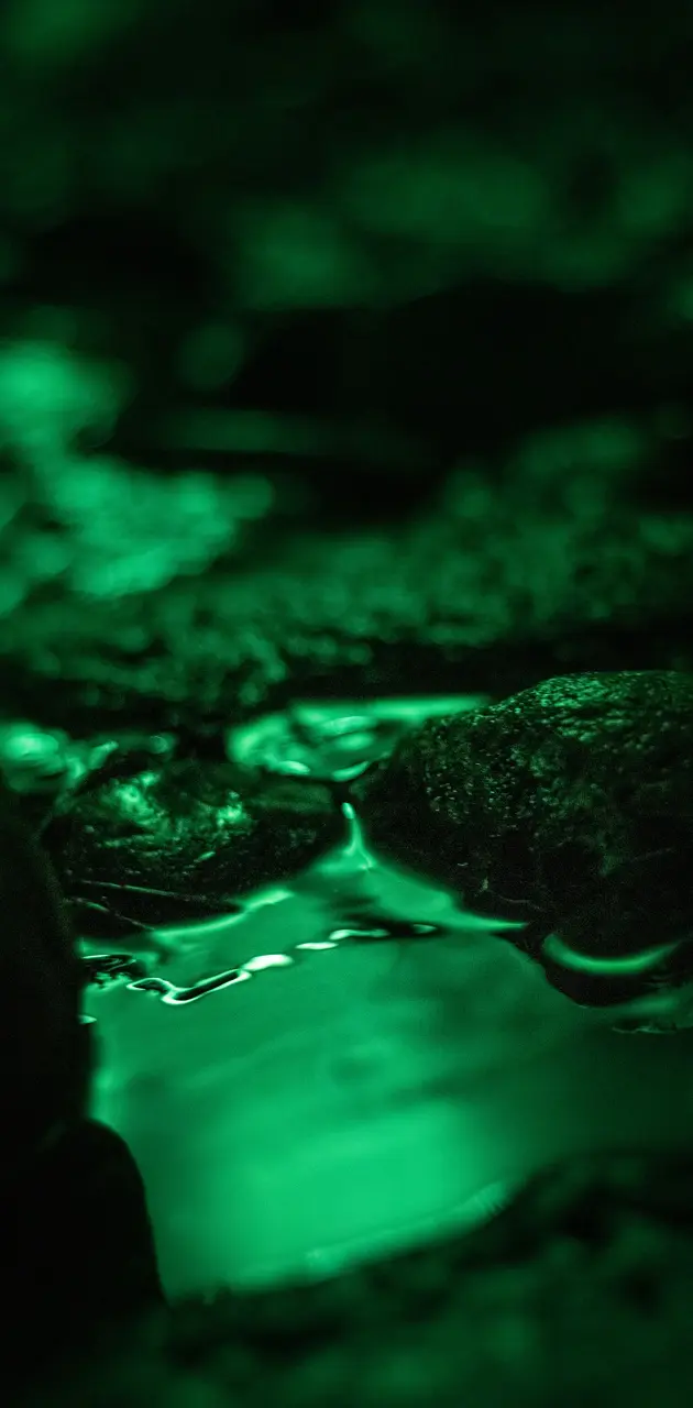 A river flowing through a cave with green lighting. - Water