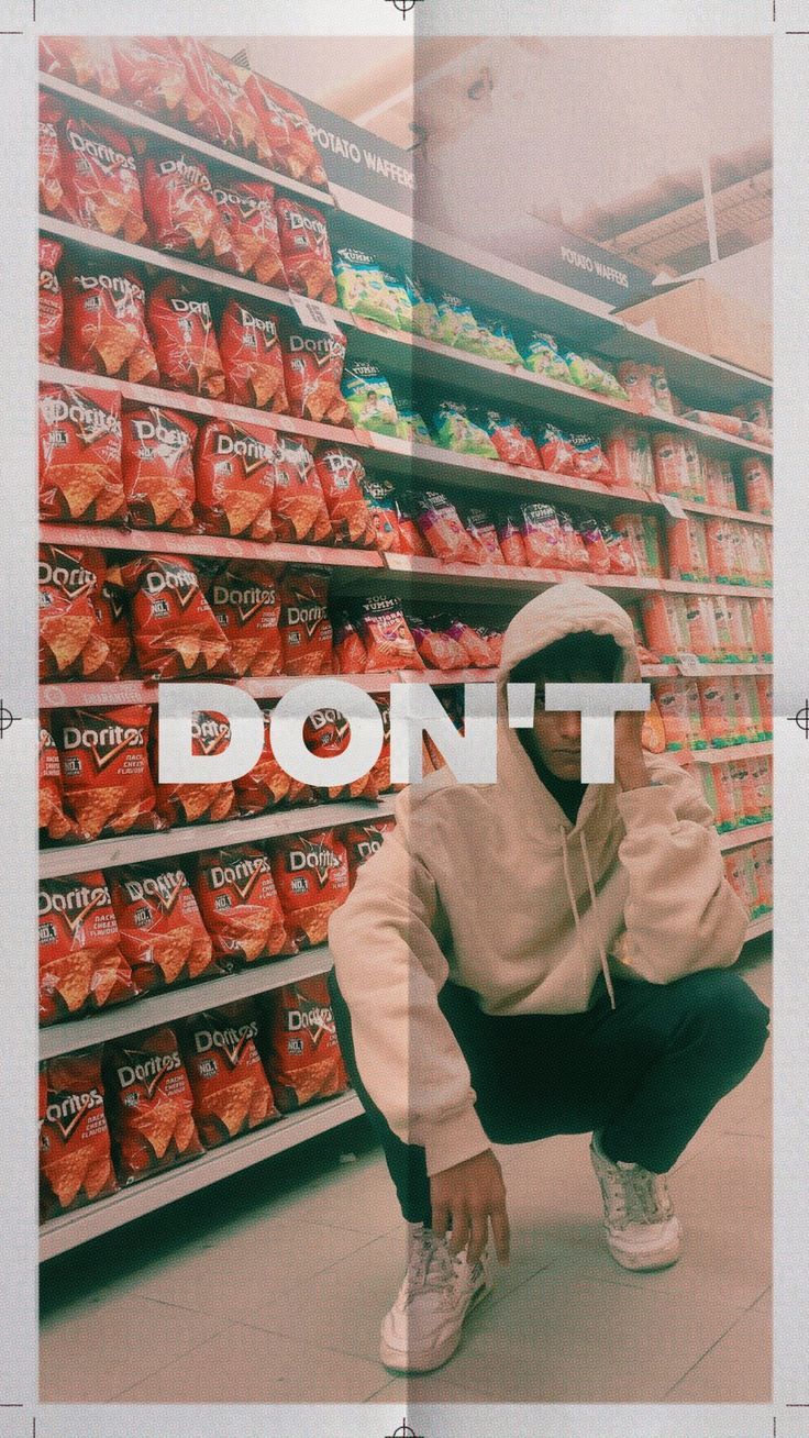 A person kneeling down in front of a display of doritos - Doritos