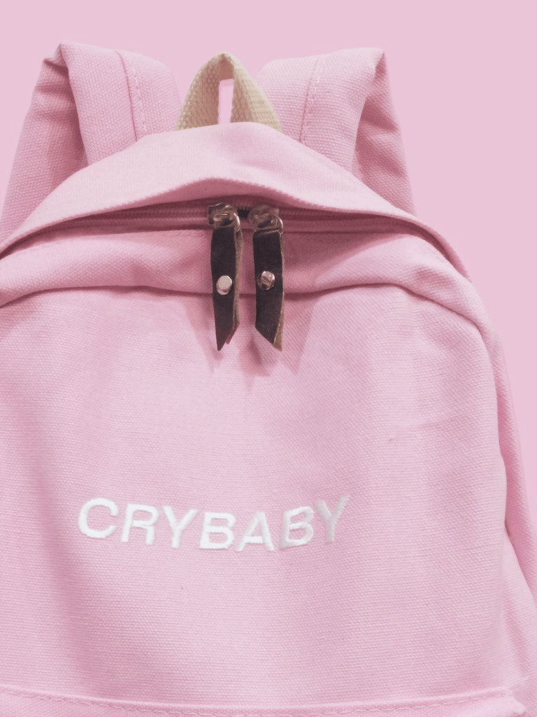 A pink backpack with the words 