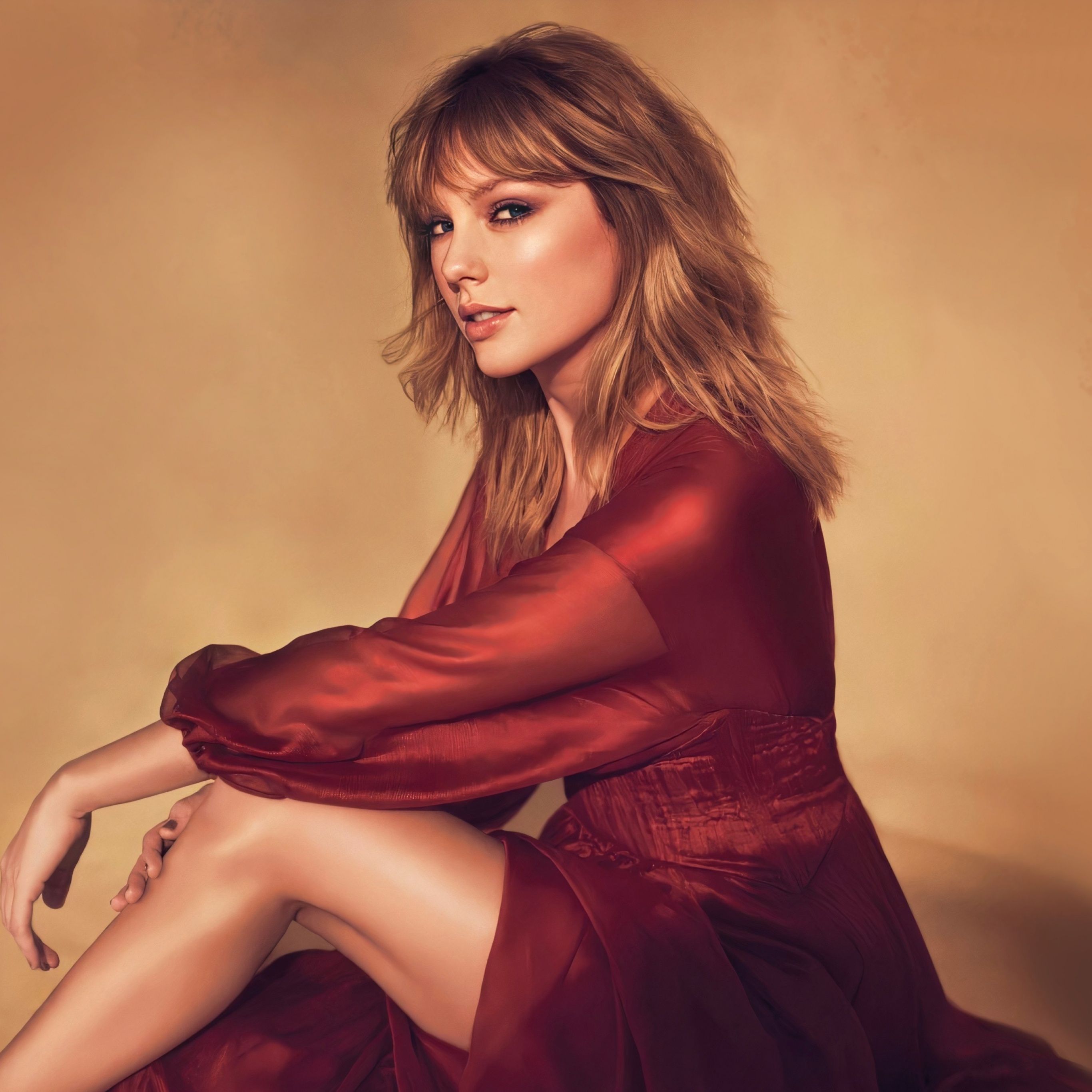 Taylor Swift is wearing a red dress and sitting on the ground. - Taylor Swift
