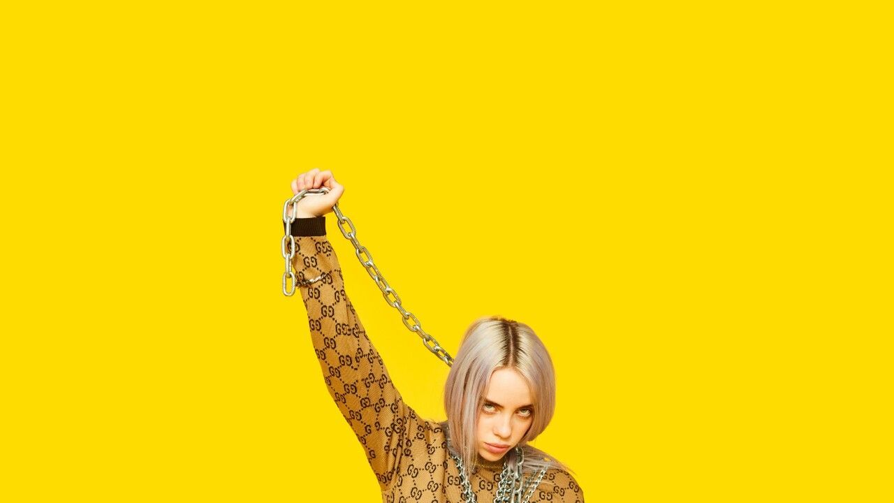 Billie Eilish holding a chain on a yellow background - Billie Eilish