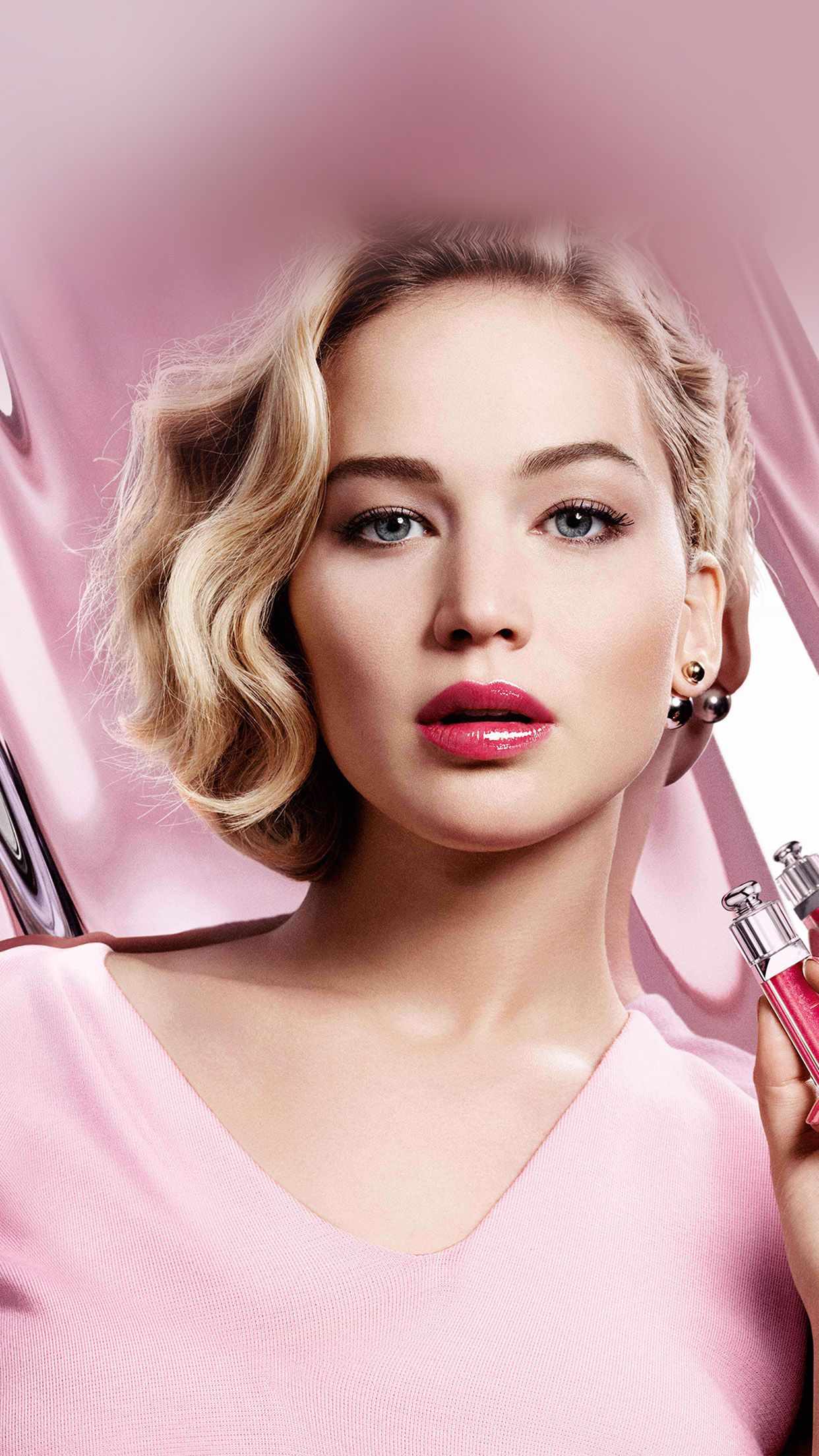 Jennifer Lawrence in a pink top, holding a pink lipstick - Jennifer Lawrence