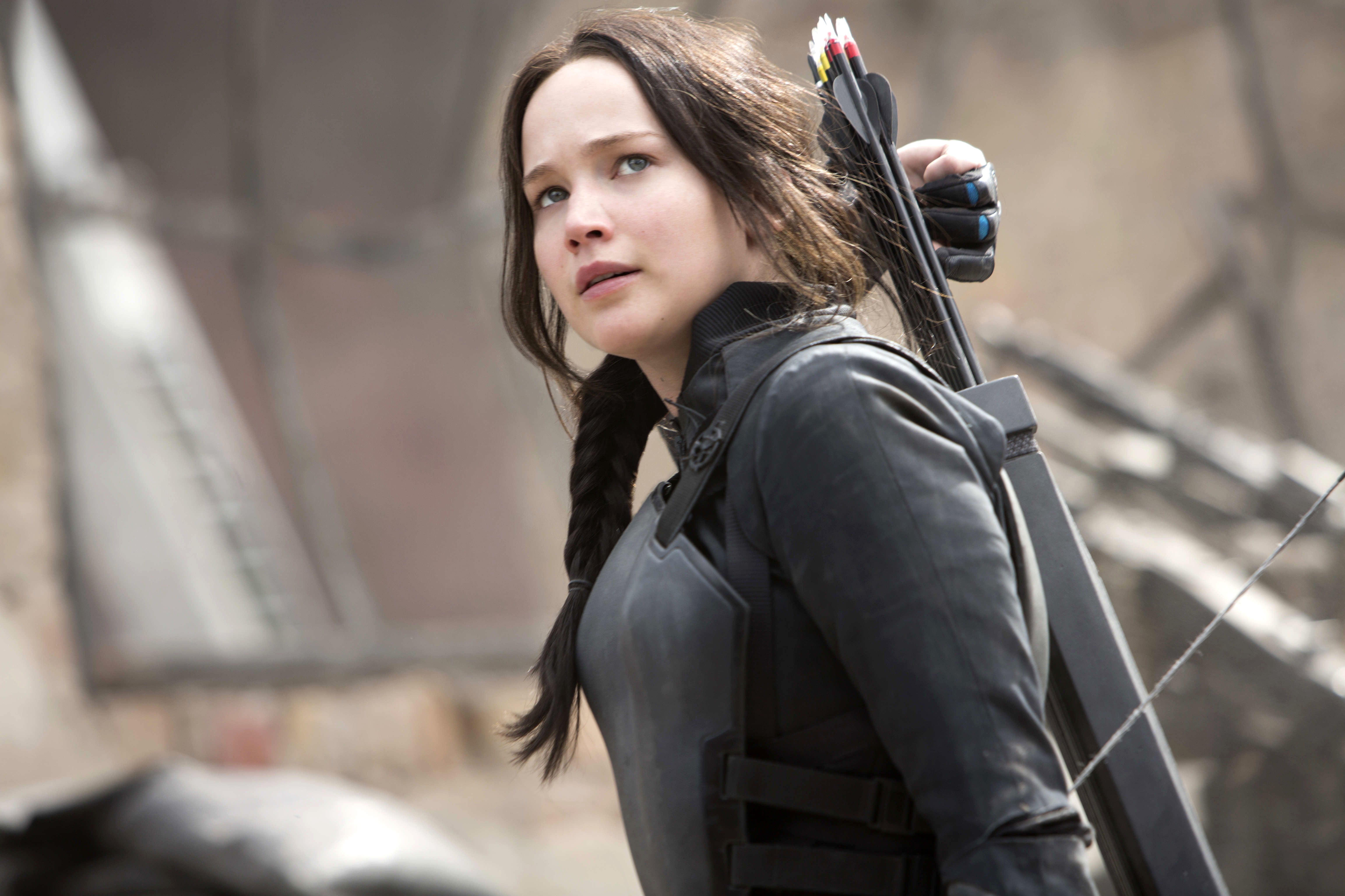 Jennifer Lawrence as Katniss Everdeen in The Hunger Games: Mockingjay Part 1. She's wearing a black leather outfit and carrying a bow and arrow over her shoulder. - Jennifer Lawrence