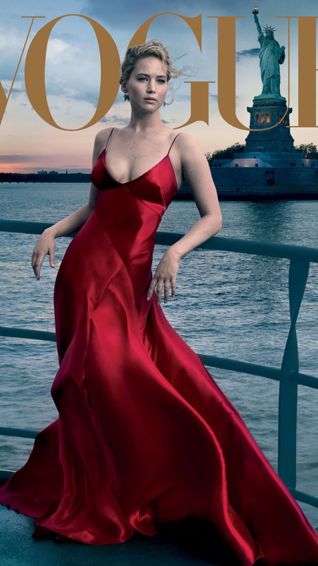 A stunning portrait of Jennifer Lawrence in a flowing red gown, taken on the deck of a ship with the Statue of Liberty in the background.  - Jennifer Lawrence