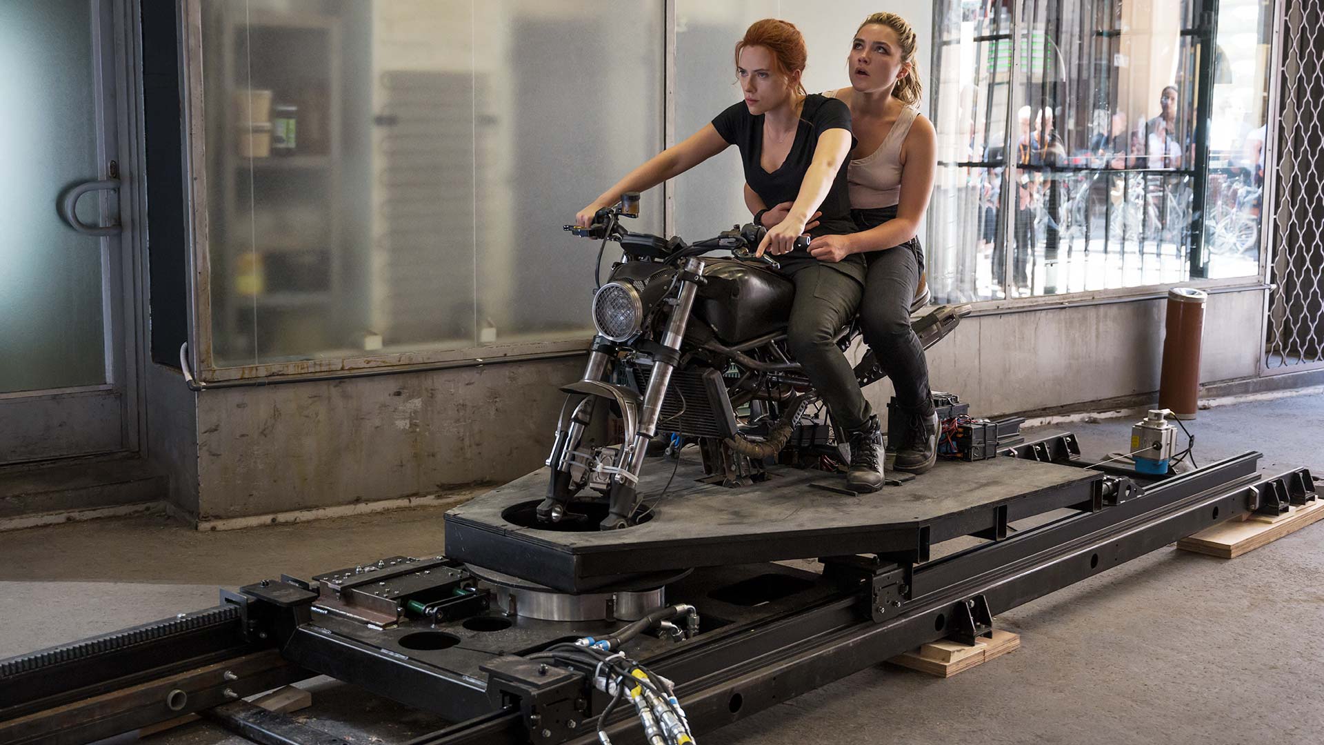 Scarlett Johansson and Florence Pugh ride a motorcycle on a track in a scene from Black Widow. - Florence Pugh