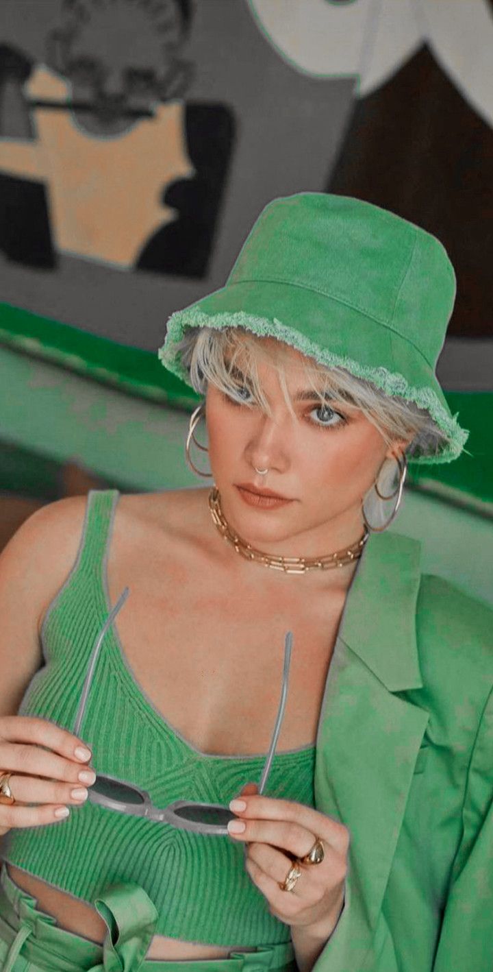 Woman in green hat and sunglasses looking at the camera - Florence Pugh