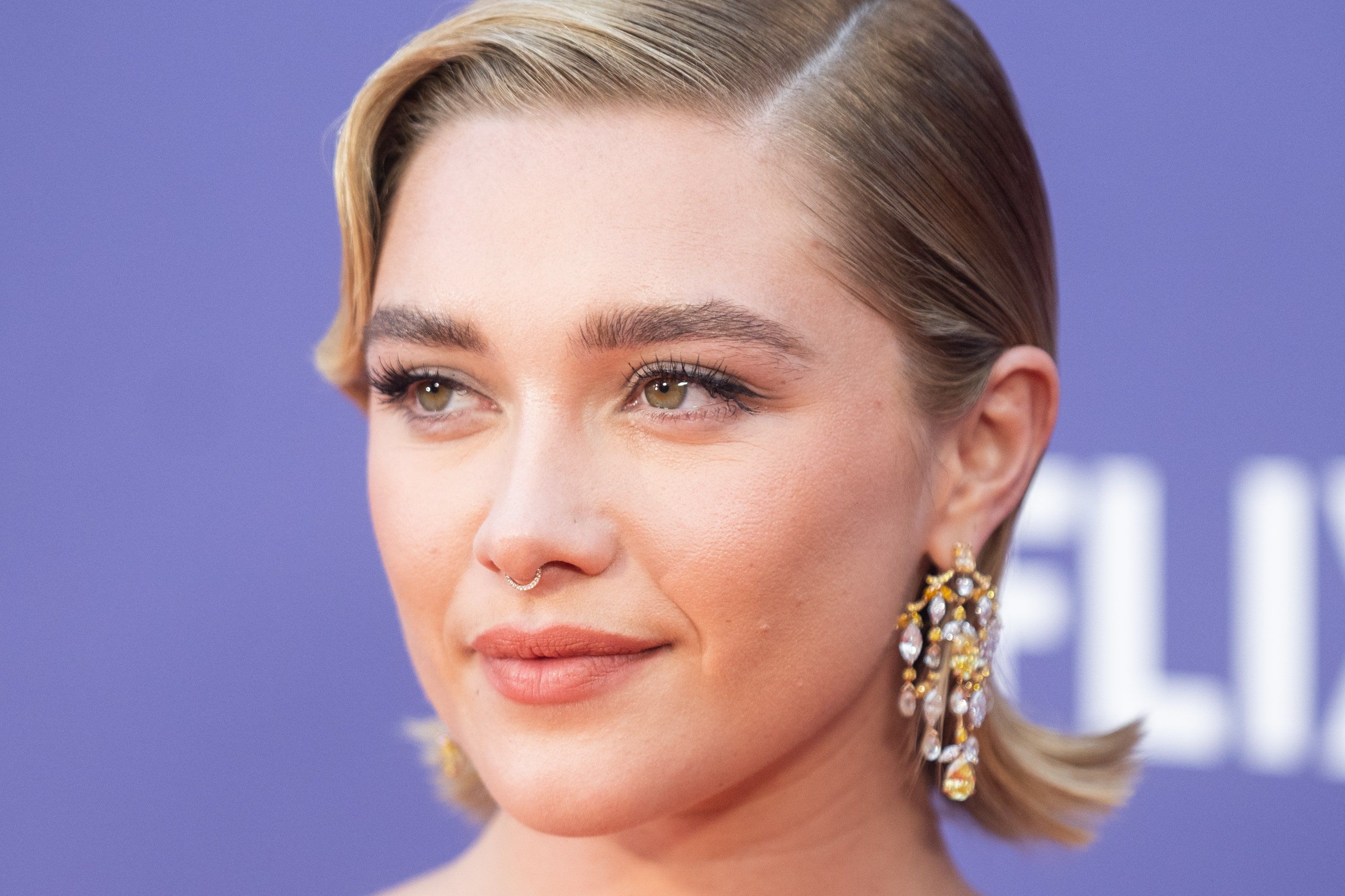 Close up of Florence Pugh with a nose ring and short blonde hair. - Florence Pugh