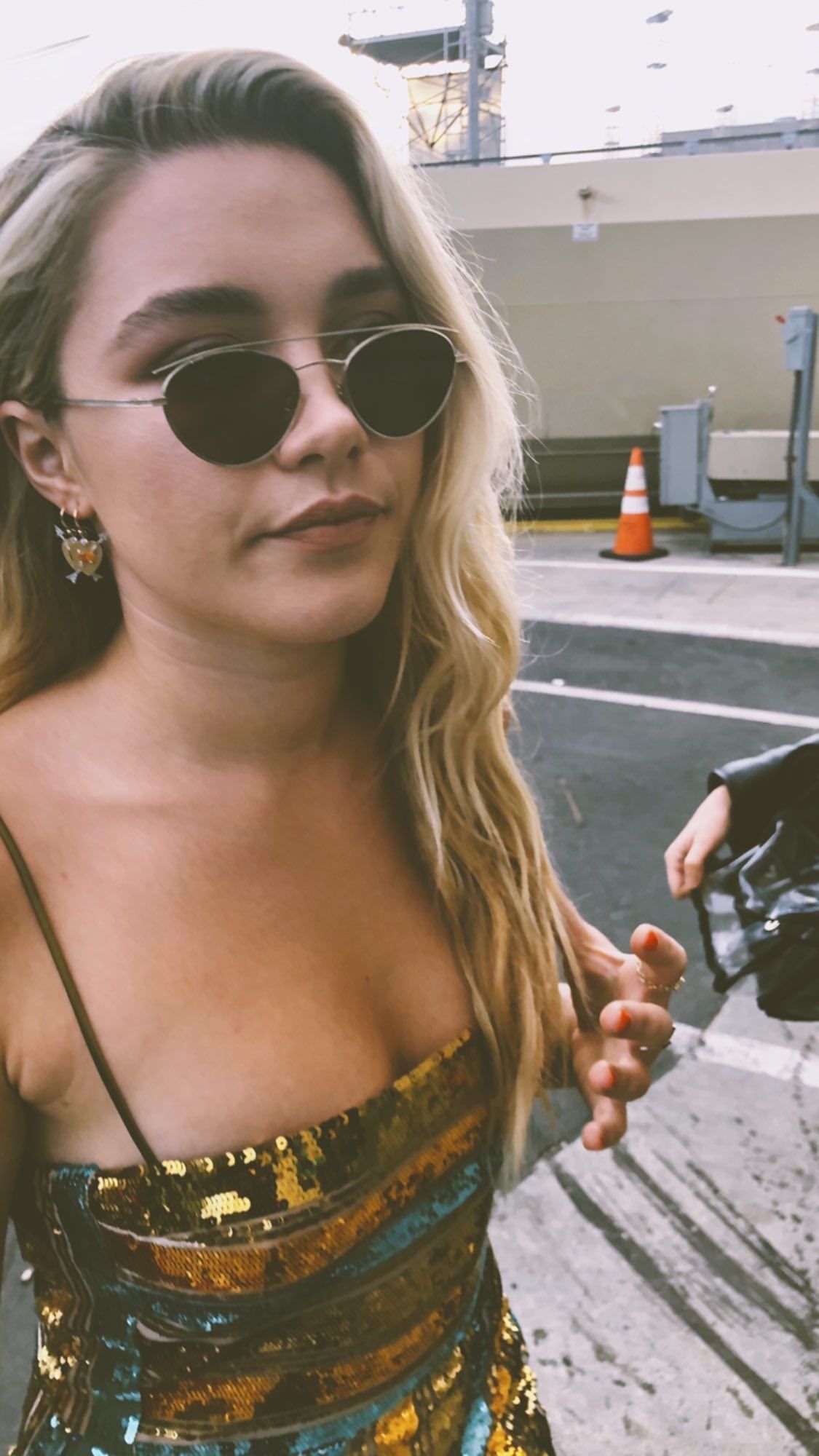 A woman with blonde hair and sunglasses wearing a gold dress. - Florence Pugh