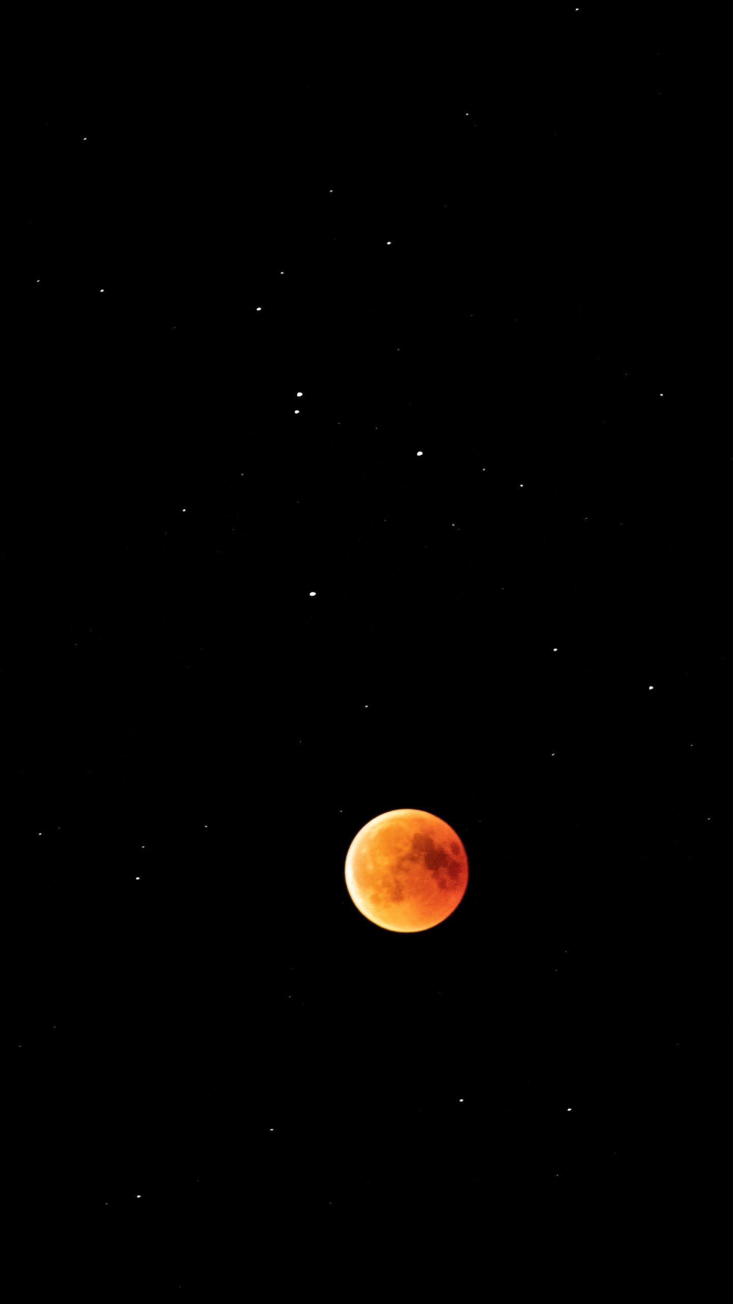 A red moon in the sky with stars around it. - Eclipse