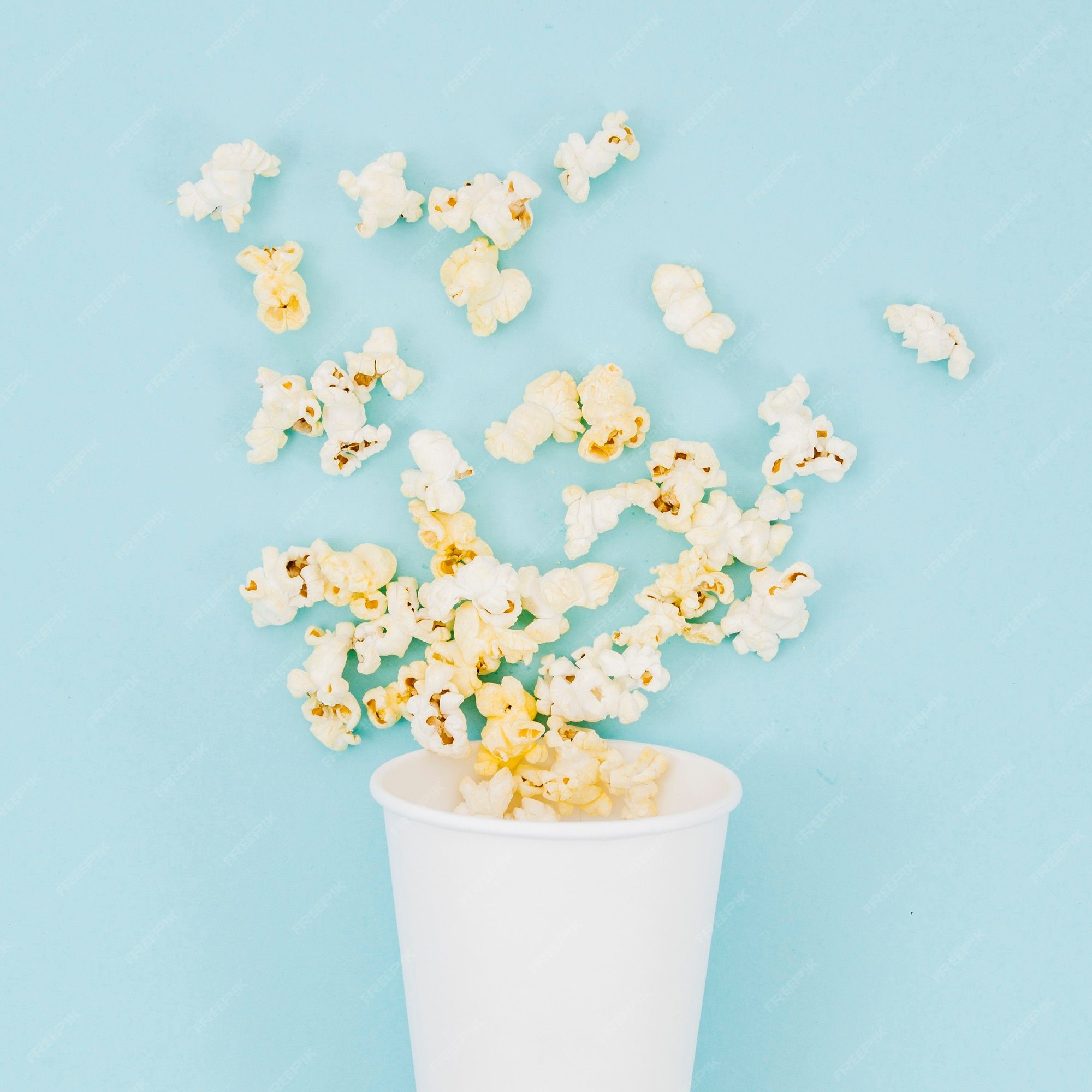 Popcorn in a white cup on a blue background - Popcorn