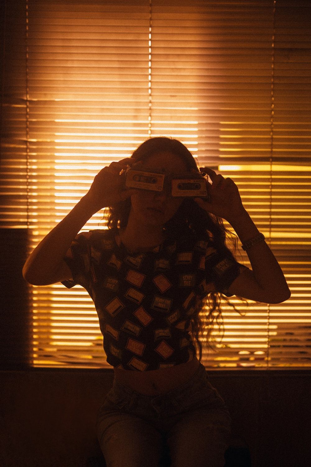 Woman in brown and white checkered crop top holding sunglasses on her forehead - 3D glasses